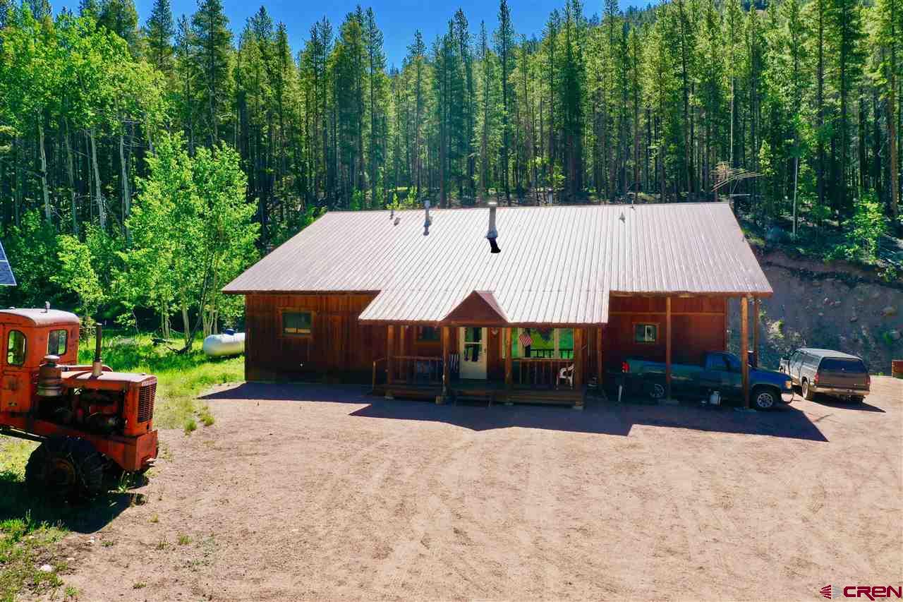 On a quiet road, less than 10 minutes from Ohio City, this secluded home on five mining claims features an excellent mixture of wildlife, nearby trails, aspen and pines. This property has 300 feet of Gold Creek frontage.  Enjoy this off grid solar hide away touched by Forest Service lands with comfortable 3 bdrm/2 bath house and woodstove for those chilly nights.  Huge attached garage, large detached barn all near the active Gold Links mine.  Property can be year-round access with the transferable plow permit from Gunnison County.  This is a retreat like no other!