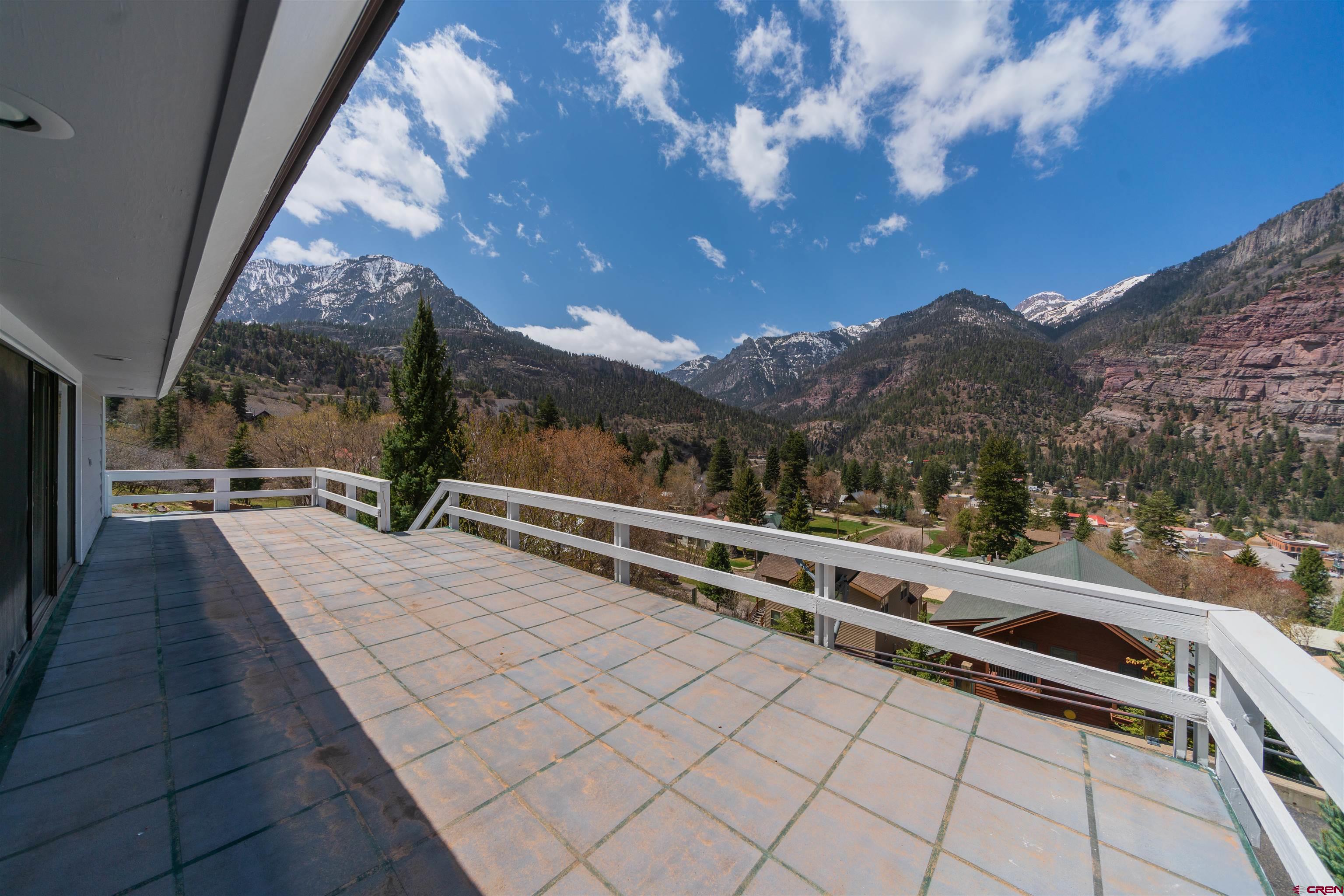 FIRST OF ALL, CONSIDER THE VIEWS FROM THIS 5,300+ SQ. FT HOME IN BEAUTIFUL DOWNTOWN OURAY.  Consider the Views from all directions.  Comtemporary Designed and built in 1972, this unique home has 5 bedrooms and 4.5 baths  with the Master Suite on the first level and four of the bedrooms on the Second level. The Master has huge his/her closets.  On the third level you will find 2 separate rooms used as office space, hobby space, library or just about anything you need.  Down stairs leads you to ground level where you find a large den/family room with a wood burning fireplace, 1/2 bath and exit to the 3 car garage.  Storage throughout this large home is incredible.  The Kitchen and living room display the beautiful hardwood floors, wood trim and T&G ceilings all in good condition.  There is a small bar/ice maker in a closet off of the living with a stereo system....definitely from the 70' s.  The living has an newer pellet stove fireplace.   The heat is Electric baseboard with the pellet stove and wood fireplace.  From the downstairs you can also access the back gardens landscaped with a flagstone patio for morning coffees or an evening cocktail hour.  The Deck, great for enterntaining overlooks the town of Ouray.  The home is Large, unique and one of a kind in Ouray.  Come and take a look.