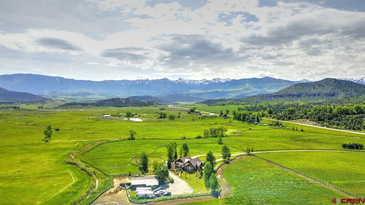 This is a magnificent, one-of-a-kind 35+ acre ranch in southwestern Colorado. Located just west of scenic Ridgway nestled in a high mountain valley at the foot of the San Juan Mountains below majestic Mt. Sneffels. “Wind Spirit Ranch” is within extremely close proximity to Uncompahgre National Forest, pristine Wilderness areas and BLM lands. This provides immediate access for seemingly unlimited miles of hiking, biking and horseback riding. Deer, elk, wild turkeys and soaring eagles are your neighbors. Gated entryway with sandstone pillars, provide privacy with class. This custom-built home is a 3 bedroom, 3 bath, with spectacular living area and spacious great room with classic overhead bay doors.  Amazing views from large windows feature the Cimmaron and San Juan Mountain Ranges or lush green meadows.  Wooden vaulted ceilings.  Beautiful stone fireplace.  Travertine showers, 8' knotty alder doors throughout, saltillo tile, and stained concrete floors.  Multiple large stone walk-out patios. Spacious dog area with custom wrought iron fencing. The ranch has deeded irrigation water and is set up for the ultimate safety of your horses or livestock. Full wooden perimeter, large arena and cross fencing made of fir with cedar posts. Attractive barn incorporates two 12’ x 24’ stalls and spacious horse corrals constructed of quality steel fencing. The barn measures 14’ x 53’ and includes a tack room, feed and storage room, built in grain bins and plenty of space for indoor hay storage accessible by vehicle. Very private yet conveniently located only 35 minutes from world-renown Telluride and a regional airport in Montrose.