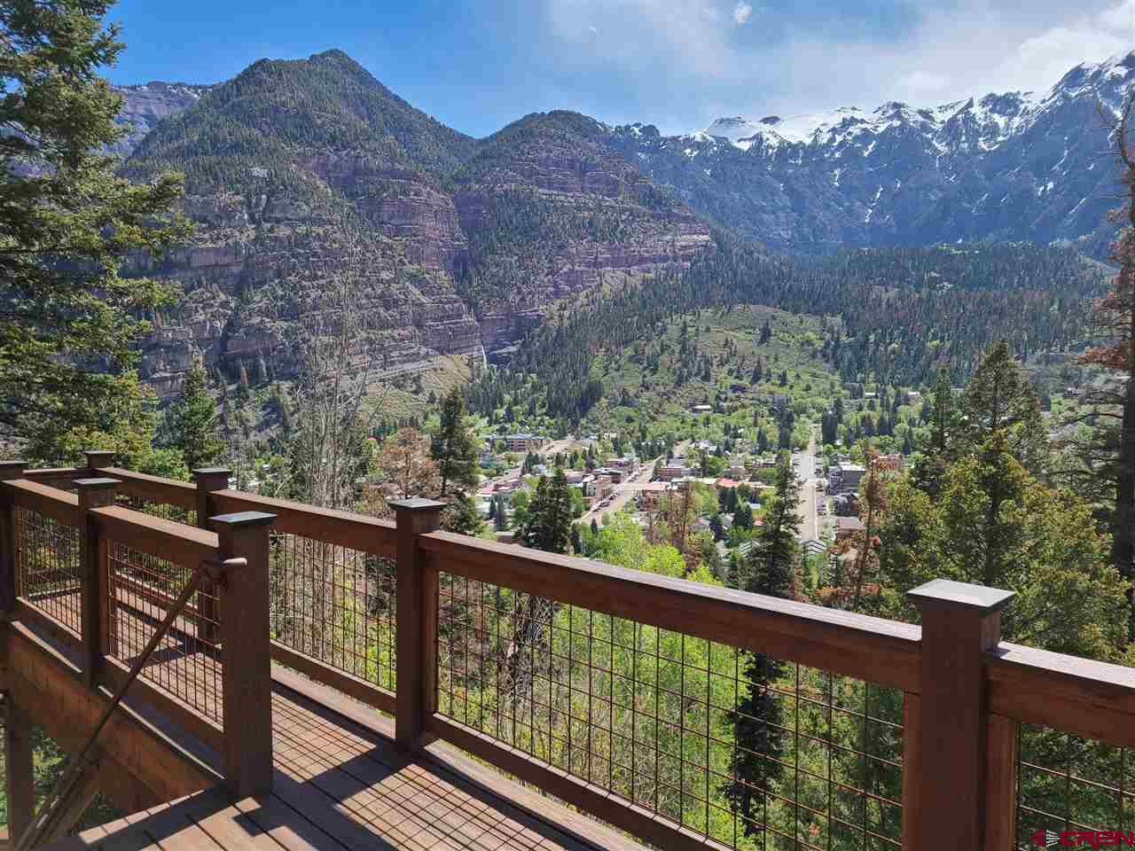 The most fabulous views above Ouray and complete privacy! 4 acres bordering National Forest on two sides with a 6.4 acre green belt below the home. Walk inside to luxury! 3 bedrooms, one with bunks, 4 full bathrooms, stone fireplace with crystals, deck looking out over Ouray and surrounding mountains, hot tub on lower patio, and a charming gas firepit on the side of the hill. Comes completely furnished - bring your toothbrush.  Stunning views in all directions are yours from this unique property! This three bedroom, four full bath home was completely renovated in 2010 with high end finishes and custom furniture throughout. The original wood burning fireplace remains and is constructed using local stones, geodes and crystals. The home is being sold completely furnished.   Stone patios surround the home and extend behind the house to an outdoor seating area with a gas fire pit and more incredible views. The large hot tub in front of the home has impressive views to the town below and the mountains beyond where you often see the alpenglow at sunset.  Windows are present in every room and bathroom of the home to take in natural light and to enjoy the views from every location. A new deck was installed in 2018 that provides for easy outdoor entertaining or just relaxing with family and friends.   The home sits on 4 acres and is protected on all sides for complete privacy. Oak Creek forms the southern boundary, national forest surrounds it to the west and north, and the east side is adjacent to a 6.4 acre green belt conservation easement between the home and the town of Ouray. A controlling interest in the green belt is also included in the price of this home. One of the access points to the Ouray Perimeter Trail is located on the greenbelt, just a few minutes walk from your front door. While you are still within walking distance to the town of Ouray and all that it offers, the home is located in the county and is not subject to city property taxes. This property is a rare gem and the views will take your breath away!