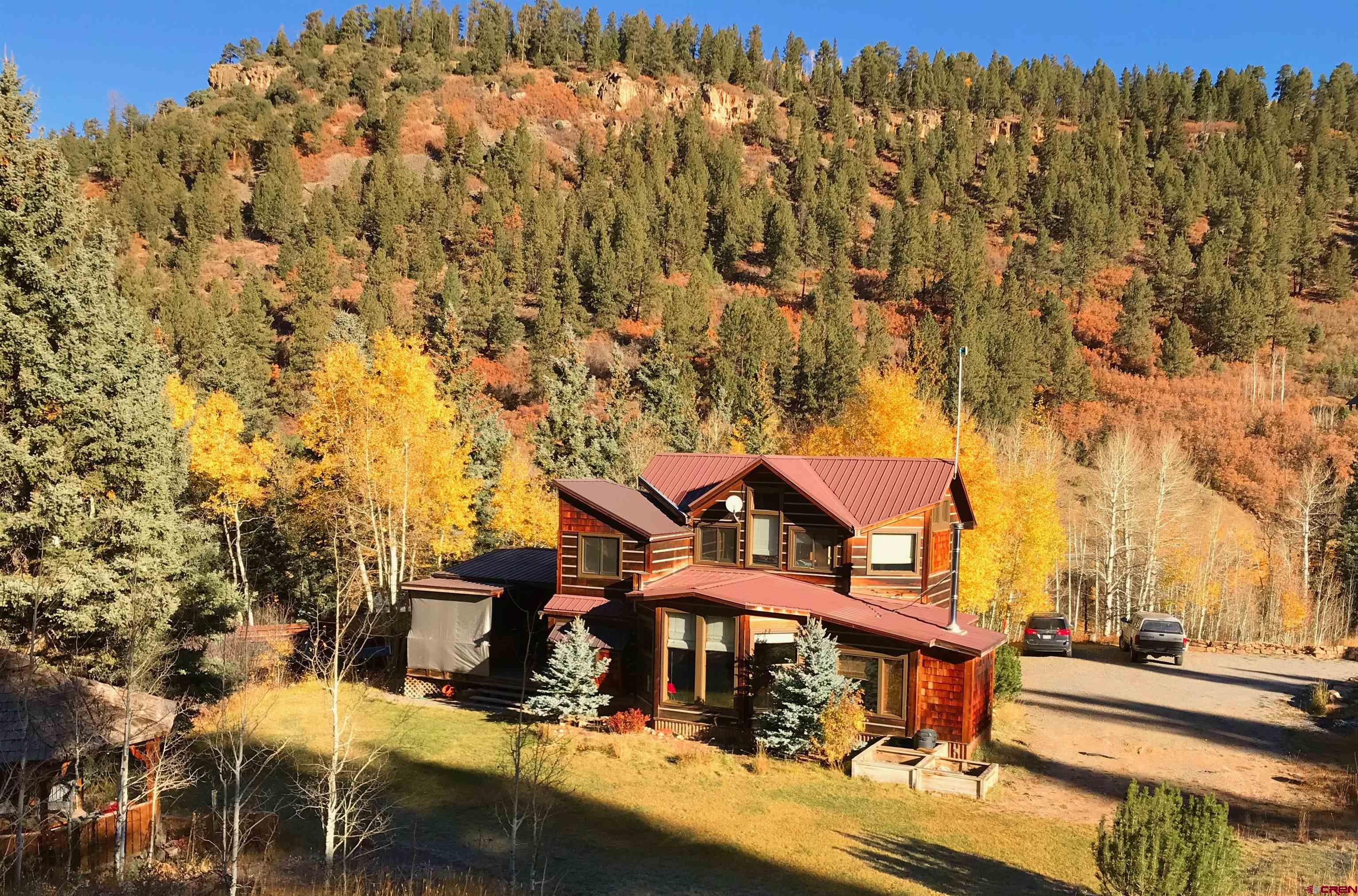THE CRAFTSMAN'S SPECIAL. ONLY 30 MINUTES TO TELLURIDE. 25+ ACRES OF ULTIMATE SERENITY. NO TRANSFER TAX. YES SHORT TERM RENTALS OK (with proper license) . This is the perfect home for someone who wants to get away from it all. With three bedrooms and two and a half baths, this expertly crafted home has plenty of space for a family or guests. Custom tile and wood work throughout give it a warm and cozy feeling, while the light and bright open living area is perfect for entertaining. The wood stove is perfect for a cold winter night, and the property is only 30 minutes from Telluride & Ridgway and all those towns have to offer, but feels like miles away from the bustle. There is no transfer tax, and the 25.59 acres of solitude and space include several accessory buildings like a shop, sheds, gazebo, AND a fully equipped, 700 square foot, 2 bedroom, 1 bath, full kitchen & washer/dryer 'tree house' accessory building*! This is a true craftsman's special close to biking, skiing, dining, music & theatre, but all the elbow room and peace and quiet you need! Relax and watch the wild turkey, herds of elk and even a bobcat or two walk by your picture windows while you sip your tea by the fire.  STR Info:  Seller has been making approximately $20k/annually very casually AirBnB-ing his home.  AirDNA estimates a potential income of up to $80k/annually.