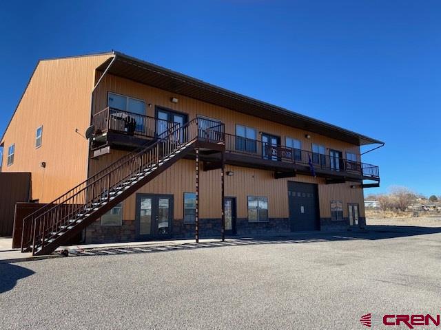 This commercial site has excellent frontage and exposure. Constructed of all of the highest quality construction methods and is heated and cooled with an extremely efficient Electric Geo Thermal System. This 9600 SF is the first phase of a Montezuma County approved 3 phase commercial site. The building is virtually maintenance free and self sustaining. There is a mixture of office, residential, and warehouse spaces that include 7 separate leases that provide a monthly income of $8500. The Upper Level contains a beautiful 1,400 sf 2 bedroom, 2 bath apartment with in floor radiant heat and is air conditioned. This apartment is nicely appointed with stainless appliances, washer/dryer and a built in entertainment center with a sound system throughout the home. In a addition to the 1400sf apartment on the upper level there are 4 more 850sf 2 bedroom 1 bath apartments with forced air heat and air conditioning. The Lower Level is entirely heated and cooled utilizing electricity and the use of a ground source heat pump. This system heats and cools the upper level larger apartment plus the lower level 800sf office, 3,600sf shop plus a 400sf laundry room, bathroom and utility room. The Septic system is highly engineered and designed for the expansion of use when and if further apartments are added ( there are stubs for septic already in place in the shop area for 4 additional apartments).