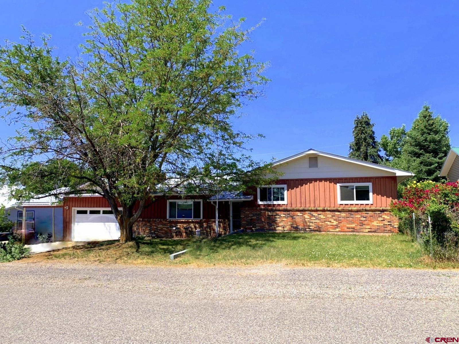 Located at the base of Grand Mesa in a pleasant in-town neighborhood, this well built home WITH extra garage/shop, fenced backyard and mature landscaping is just waiting for you.  Efficient considerations with a newly installed 4kw solar system, metal roof, vinyl windows and sliding doors, plus attic fan and motorized awning for passive cooling.  Large living room with wood stove insert and open Dining/Kitchen areas.  Bedrooms located on raised half-level.  Spacious attached garage plus 1-car carport, and a 20' x 14' detached shop on a concrete slab.  Front and back lawns with sprinkler systems, plus roses, forsythia bushes and 2 dwarf apple trees.  Enjoy the spacious back yard and the 2 person hot tub.  This property maximizes it's space and offers plenty of garage storage for your toys!  Welcome home...