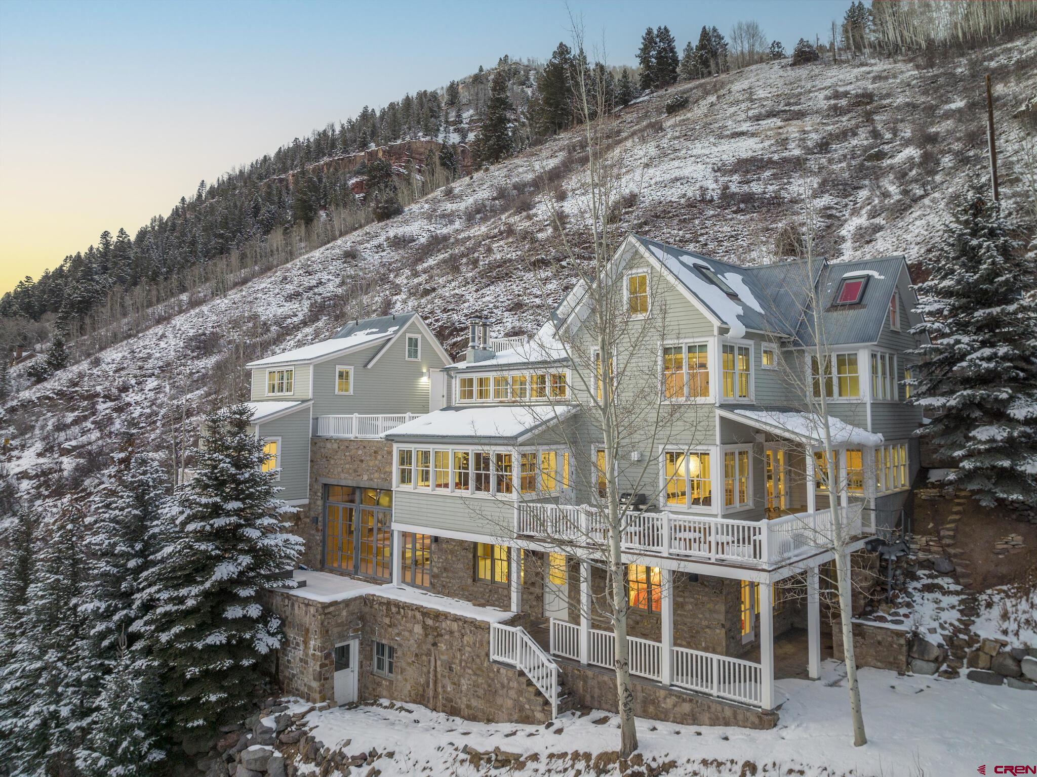 With views overlooking the historic town of Telluride and ski area along with sweeping vistas of the towering Peaks of Ajax, Ballard and Wasatch mountains, this stunning residence offers 6983 square feet with 8 bedrooms and 5.5 baths including a 2 bedroom, 1 bath guest/caretaker suite. A spacious great room features a floor to ceiling fireplace and walls of windows to enjoy the sun drenched panoramic views. On the lower level is another large entertainment space with loft and a wall of French doors leading to a spacious terrace and hot tub. Located just five blocks from the gondola, this Telluride home is a dream residence for skiers, hikers, and anyone who wants to escape to the San Juan Mountains.