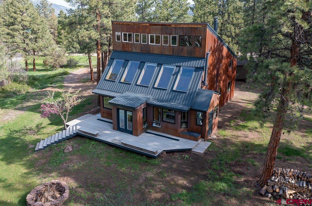A tranquil park like setting in an Aspen grove with towering Ponderosa pines sits a contemporary home with some unique features.  This home has three bedrooms and two full baths, a great room and a very cool sun room, perfect for a green thumb.  The house has had an extensive remodel.  New flooring, beautiful gas fireplace, paint, counter tops, kitchen appliances, walk in shower, baths, windows and exterior paint.  There is a nice bonus room with a little loft area.  Perfect for a play room or a studio. The passive solar gain with the south facing sun room makes the house light and bright and warm in the winter.  A beautiful deck and fire pit along with an awesome swing adorns the back yard.  The setting of this home is quiet and peaceful.  County maintained road to the highway and half way between Ouray and Ridgway.