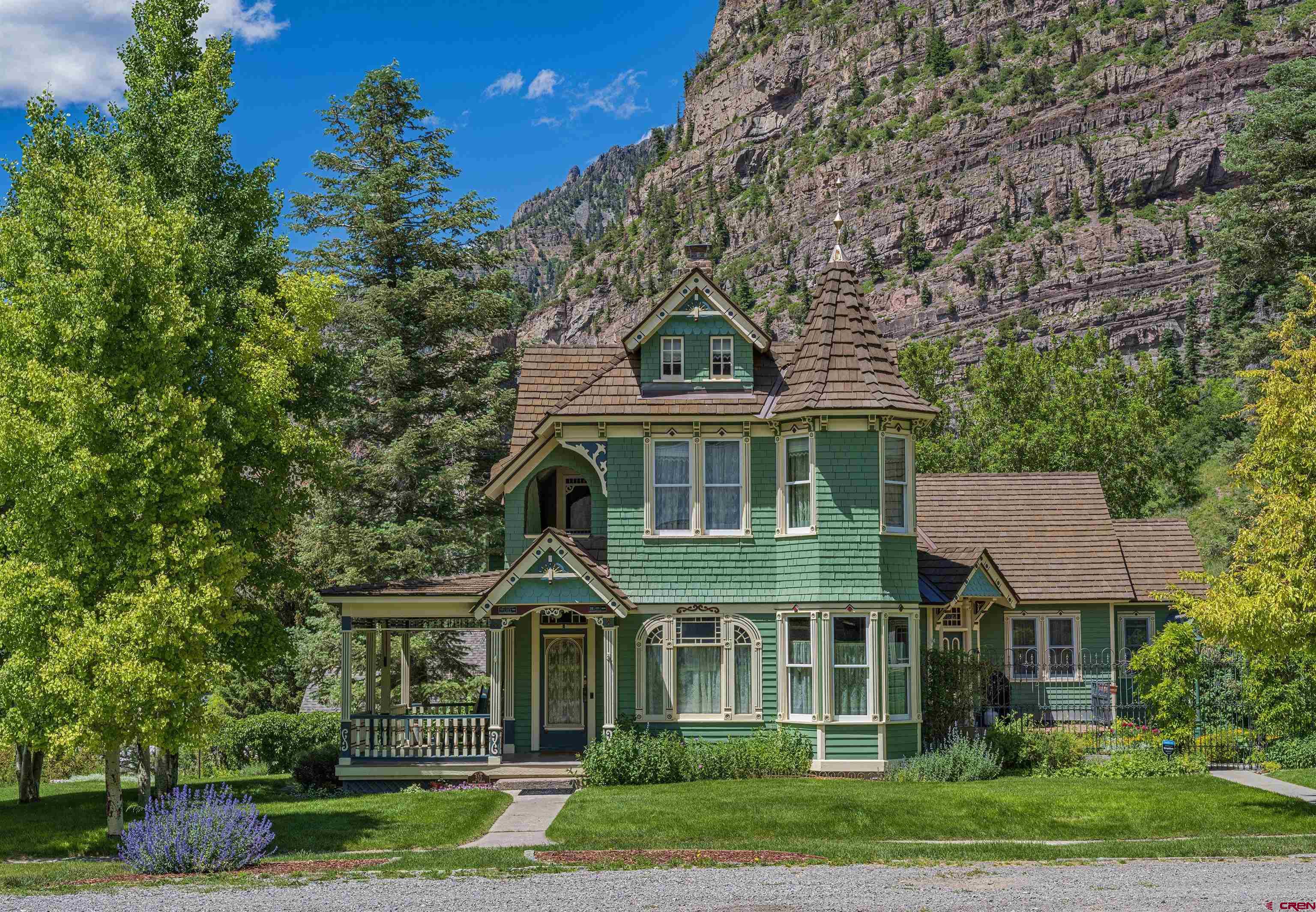Timeless, Iconic Victorian home in Ouray.  This home is photographed more than any other home in Ouray.  Built in 1898 this beauty has been immaculately cared for through the years.  The home has two formal bedrooms and one flex bedroom with a sauna and murphy bed, a sitting area, an eyebrow deck and two bathrooms on the upper floor.  There is a large bedroom with a walk in closet and gorgeous bath on the main level along with the kitchen, dining room, parlor, library, butlers pantry, laundry, side entrance and half a bath. The lower level has a bunk room with four bunk beds and a queen bed along with an adorable kitchen, with red appliances, and a bath.  There is a separate entrance in the lowest level.  One could make this into an apartment for a care taker.   The kitchen has soap stone counter tops, period new appliances, an authentic old farm house sink, and beautiful cabinets with wainscoting doors to match the walls.  Two of the baths boast claw foot tubs.  Old push button light switches, beautiful hardwood and tile floors, gorgeous original trim, beautiful wallpaper, and antique fixtures are just a few of the many features adorning this home.  This home sits on four city lots and is full of perennials, aspen trees, a bocci ball court and a two car detached garage with storage above.  The roof was replaced two years ago with a composite product made to look like wood shingles with an 80 year guarantee.   The amenities are too many to list.  Come see this stunning home for yourself.