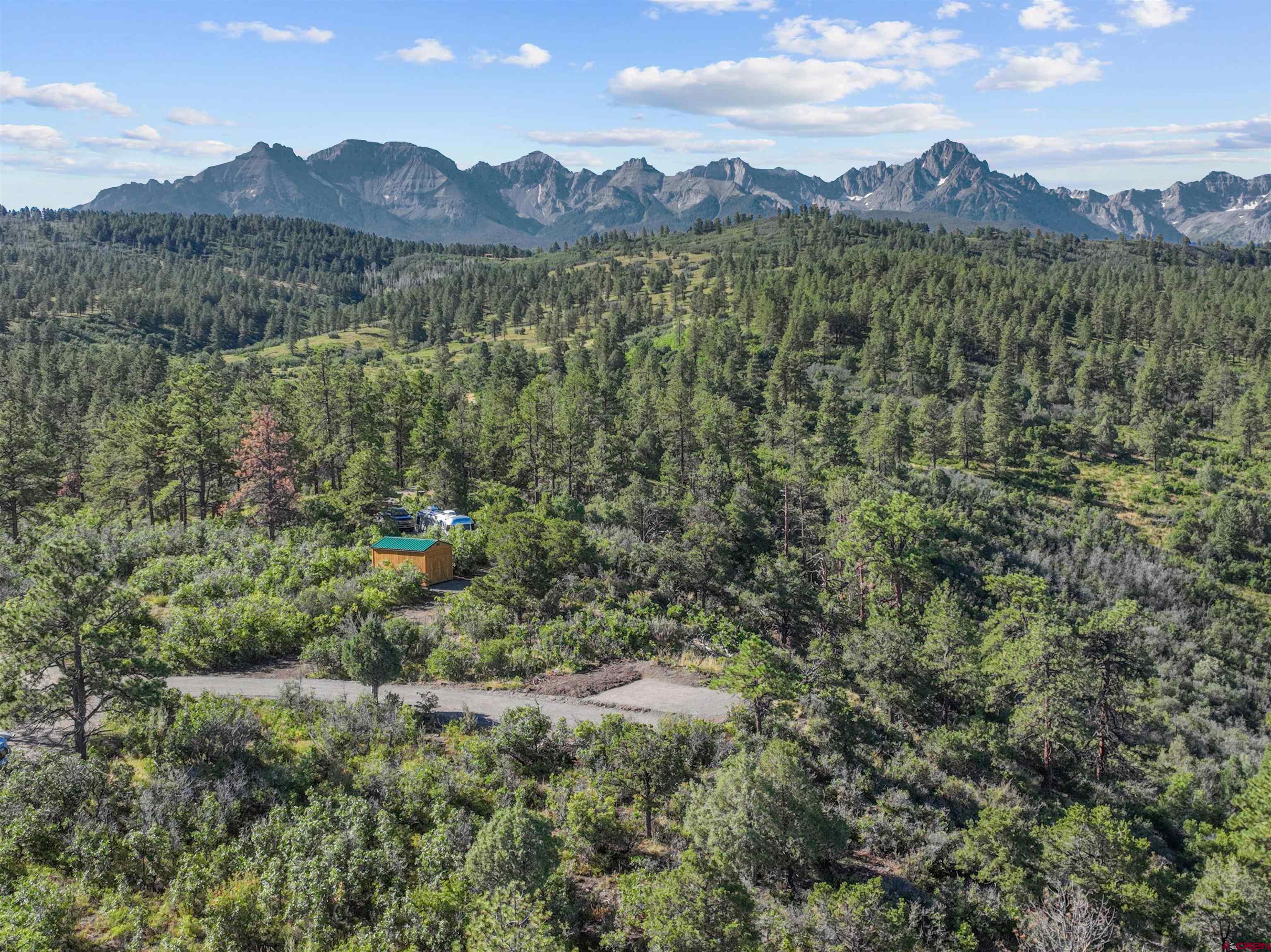 The opportunity to own one of the few 35-acre parcels in High Noon Ranch just south of Ridgway does not come along very often. Standing on the property while gazing across dense ponderosa pine forest at unobstructed views of the Sneffels and Cimarron mountain ranges, it is easy to understand why. Situated atop the low density and highly desirable Miller Mesa, you'll find yourself immersed in the remote Colorado mountain dream while being only 5 minutes from town. The build site includes a recently cleared hillside driveway and adjacent 400sf patio area with incredible views that could be used as part of your future home or as a separate spot for an RV, tiny home, or carriage house. Electric and well are already in place, including a 50amp power pedestal currently in service, as well as a topographical survey and the results of a soil test. All the legwork has been done so you can begin designing and building your dream mountain home immediately. A natural spring lower on the property contributes to the abundance of wildlife that passes through the area. Strong cell service and Starlink internet makes staying in touch and working remotely a breeze despite the rustic setting. Come imagine sitting on your deck and watching the alpenglow light up Mt. Sneffels at sunset without a single manmade structure in the foreground before fading to allow the Milky Way and shooting stars to take center stage.