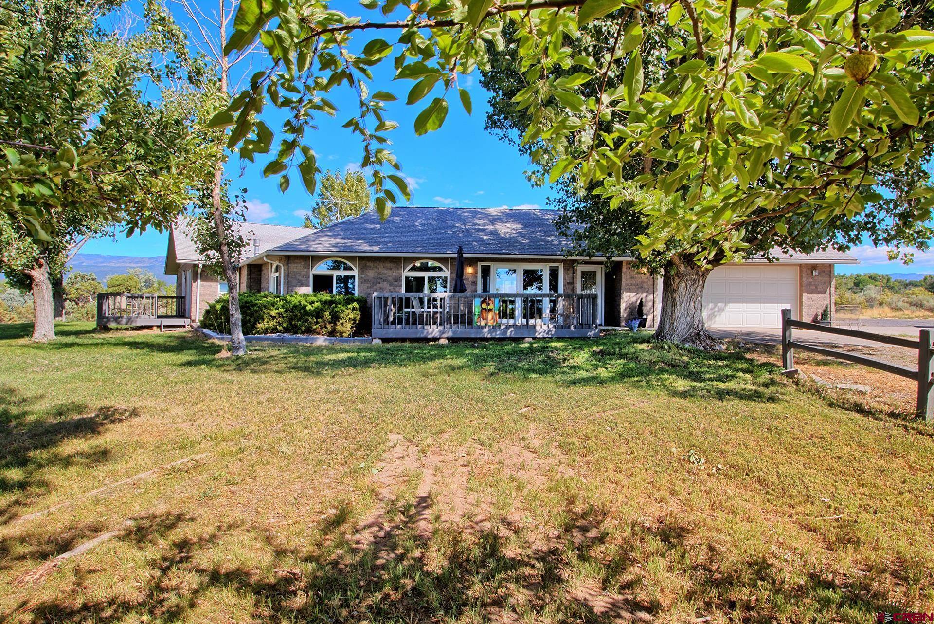 Tucked away in a prime Cedaredge location this 2000+ sq. ft. home is situated on 9.19 irrigated acres surrounded by native landscaping and green meadows with plenty of wildlife to be viewed. Good privacy and views with several great outbuildings. The clean and move-in ready home is 4 bed/2 bath with attached 2 car garage with No Steps at all into the one level home. New luxury vinyl plank flooring throughout the main kitchen and living area. Radiant in-floor heat fueled by Natural Gas. 3 springs on the property provide adequate water for outside landscaping around the home and to keep the meadows green. Additional outbuildings include a detached 2 car garage/shop that is plumbed, heated, and cooled, a large pole barn style building completely enclosed to include a 16x32 stall, a 24x40 two stall with an oversized door for RV Parking and a 2 stall carport on one side giving you exceptional covered storage. Overall a great secluded setting but close to town with a very nice home and wonderful Grand Mesa views!