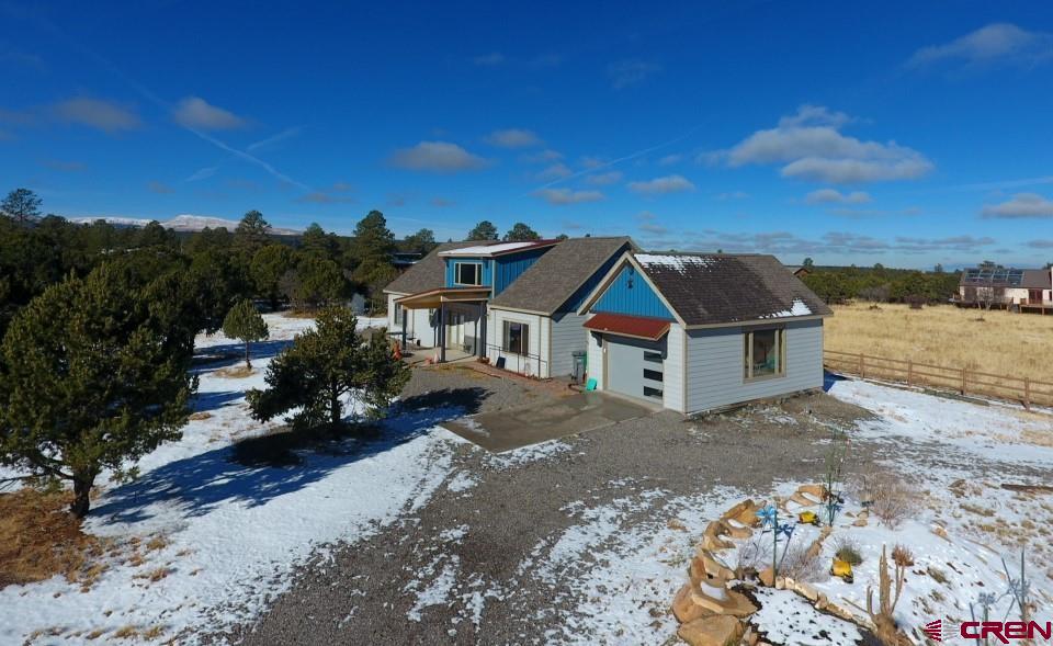 Fairly new home built in 2020 nestled into 1+ acres in Loghill Village. South facing and situated on a cul-de-sac off of Ponderosa Drive.  3 bedroom, 2 full baths plus two 1/2 bath with approximately 1992 sq. ft. of heated space. There is also an enclosed area between the garage and home that could be a perfect office, reading room, art room, etc.  Views of the San Juan Mountains from ground level and huge views from the second story.  Nicely laid out kitchen including over-sized refrigerator, dishwasher, oven and stovetop.  Generous sized pantry.  Dining area is adjacent to the kitchen with ample space for nice dining table and chairs.  The living room includes a gas stove for ambience and backup heat.  There are 2 primary suites on the main level with an extra guest bathroom.  The main level bedrooms are nicely sized and both have full baths and walk in closets.  They both also have private ingress/ egress. Upstairs is an open bedroom/ flexroom with huge views.  There is a additional 1/2 bath up as well.  The square footage of 1992 does NOT include the 2 spacious unfinished upstairs areas.  These 2 areas add approx 541 square feet, and it will not take much to finish these areas off.  A single care garage adorns the east side of the home.