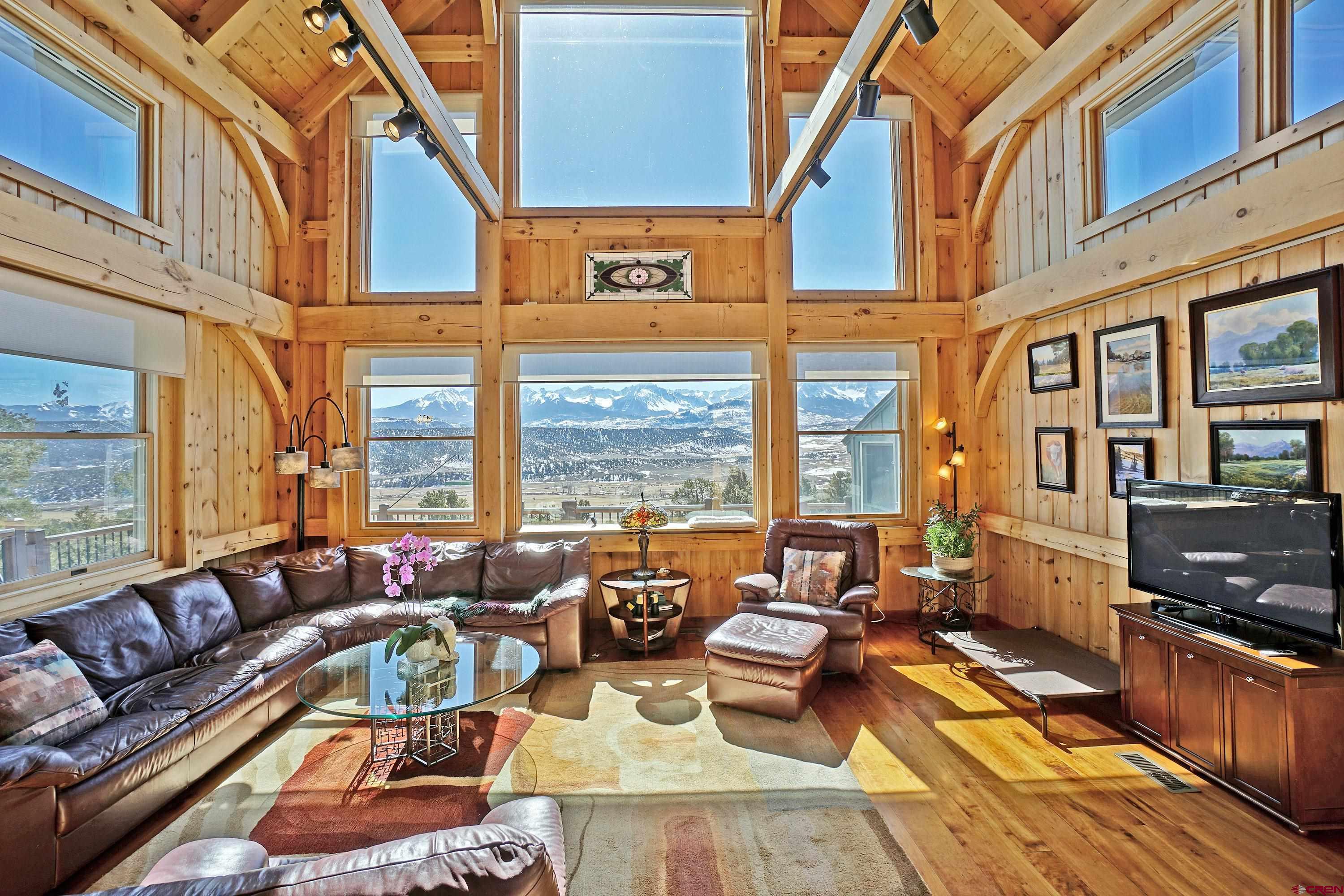 When you think of the Colorado and your dream home, it is about the mountain views.   You want a home with the BIG mountain views.   What does that mean?  You want to see Mt Sneffels framed by your living room windows.  You want to see all of the San Juans and all of the Cimarron Mountains.   You want to see Chimney Peak and the Courthouse turn yellow, orange, pink, lavender with the evening Alpenglow.   This Pleasant Valley 4 bedroom, 3 bath home situated on 3.14 acres checks all of the boxes.   Come in the front door and immediately you are surrounded by the cozy warmth of post and beam construction.  The open floor plan flows from living room, kitchen and  to dining room.  2 Sided Fireplace warms living room and kitchen open space.  There are 2 master suites, one on the main level and one on the upper level.  The lower level features 2 bedrooms, one full bath, living room, sun room and walk out to the garden.  It is a home which invites the outside inside with decks bounding the dining room and living room.  Need space for vehicles and toys?  Got it with an oversized 2 car detached garage with studio space above.  Well established yard and garden with drip system is fenced for you and your pets enjoyment.  Pleasant Valley is known for its magnificent mountain and valley views.  It is a location close to where you want to go.  15 mins to the Town of Ridgway, 40 minutes to Telluride, less than an hour to the Montrose Airport.    Hike, bike, walk, run right from your front door.