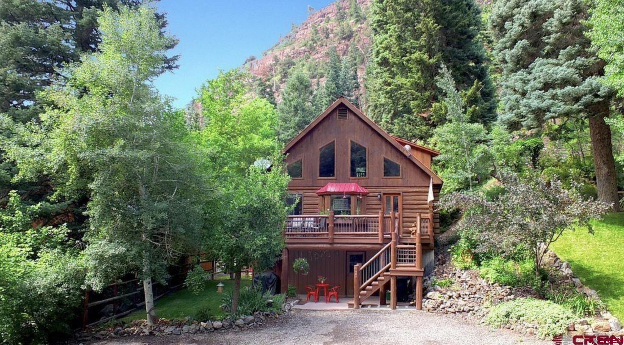 Welcome to your own piece of paradise located in the City of Ouray. This a stunning log cabin boasting 3 bedrooms and 2 1/2 bathrooms with breathtaking mountain views. Step inside this meticulously renovated retreat to discover a haven of comfort and style. The interior is presented with all-new appliances and exquisite quartz countertops new sink and garbage disposal, all new toilets, complemented by fresh paint that revitalizes both the interior and exterior. Revel in the warmth of newly carpeted floors and refinished wood floors that add a touch of rustic elegance to every room. Each bedroom is adorned with new mattresses and linens, ensuring a restful night’s sleep after a day of adventure in the mountains. This charming cabin features not just one, but two fully equipped kitchens, along with two convenient laundry rooms. With a lock-off option to separate the loft from the downstairs area, you have the flexibility to utilize the space for short-term or long-term rentals, maximizing its potential as an investment property or private sanctuary. Step outside onto the expansive decks and patios to bask in the beauty of the surrounding landscape. Just .10 mile to walking trail along the Uncompahgre River. Enjoy al fresco dining and entertaining with two brand new Weber grills, while taking in the sights and sounds of nature. The beautifully landscaped grounds feature apple trees, majestic pine trees, and quaking aspens, creating a tranquil oasis where you can escape the hustle and bustle of everyday life. Whether you’re seeking a peaceful retreat to call your own or an income-generating property in a prime location, this log cabin offers the perfect blend of luxury, comfort, and natural beauty.