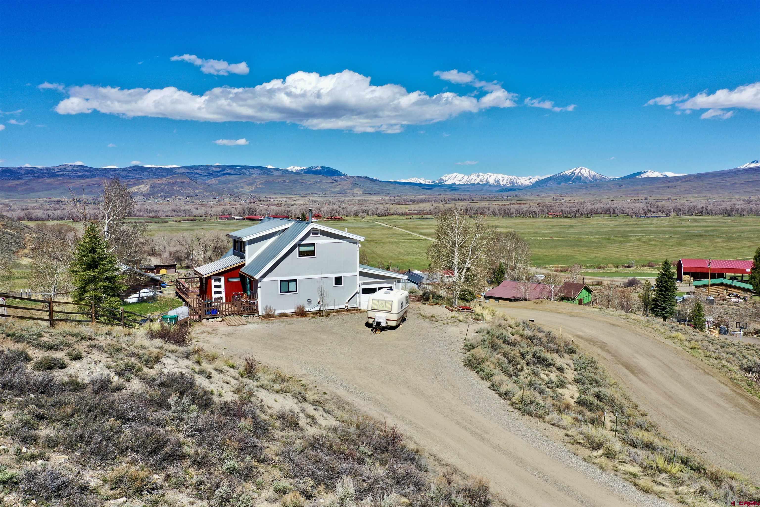 Welcome Home to 99 Candlelight Lane!  Phenomenal views of Red Mountain, Anthracite mountain range, & Ohio Creek valley ranchlands.  Charming and inviting 3 bdrm/2 bath, 1786 square foot home with new mudroom, open kitchen with granite counters, dining room, living room & pellet stove all located near Cranor Hill ski area.  Attached one car garage, fenced yard & trees.