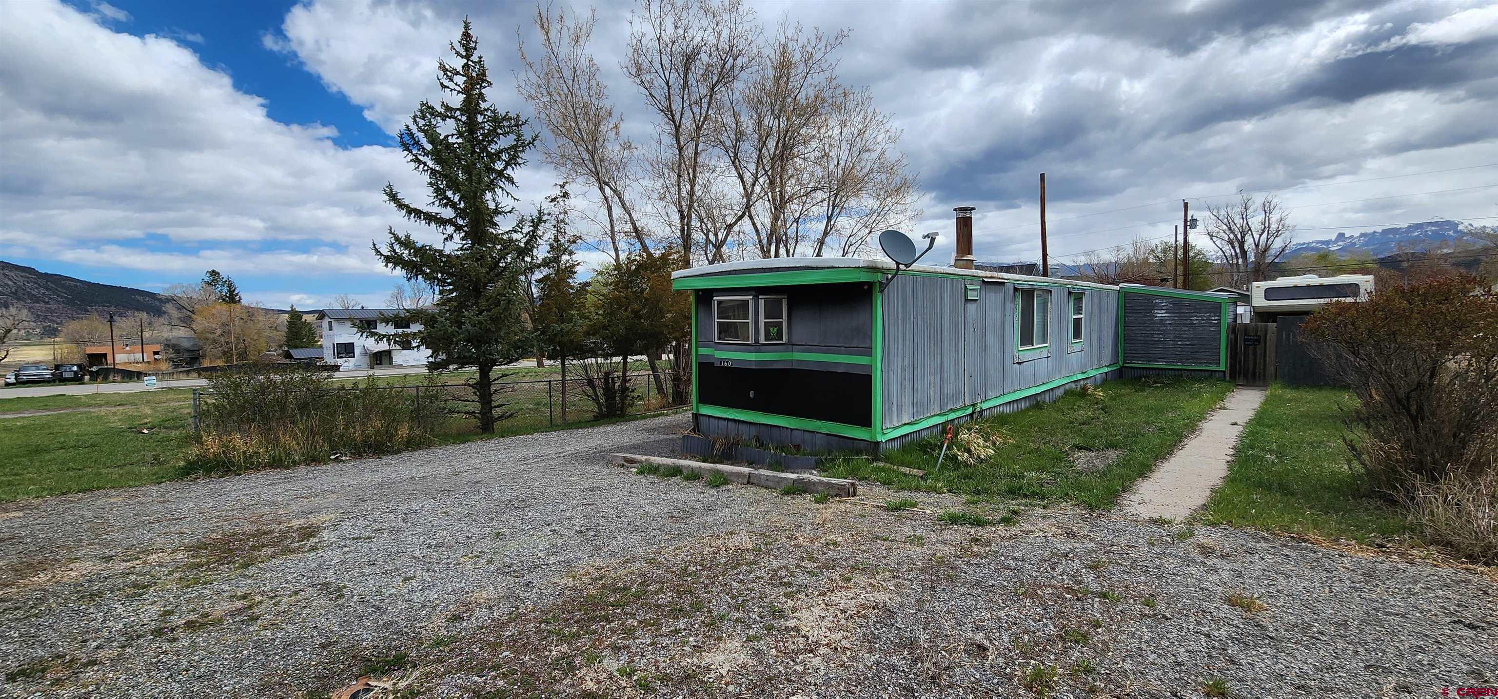 Two lots in town within walking distance to everything in Ridgway Colorado. Property has a mobile home with two sheds and some lean-tos. Details in listing 812995. Water and Sewer tap included. Flat and level and full depth parcel - street to alley. Adjacent parcel is also for sale.