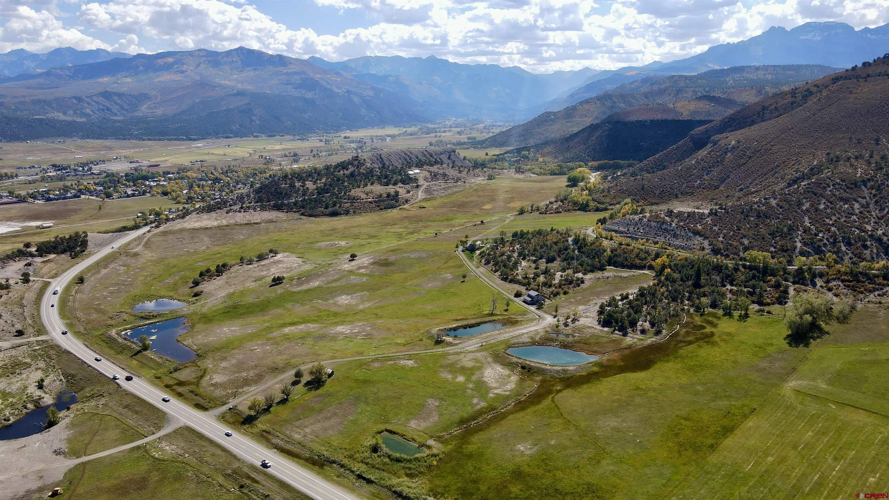 Perched in a picturesque valley above Ridgway, this unique property offers expansive views of the Cimarrons, Ouray Valley, and the Sneffels Range. Encompassing 159 acres, it creates a private enclave just outside the charming town of Ridgway. The land benefits from Dallas Creek water rights, ensuring lush green pastures that attract abundant wildlife. A resident herd of over 100 elk frequently grazes and roams the property, creating a truly immersive natural experience. Coyotes, foxes, mule deer, and a variety of bird species also make their way across the land, adding to the property’s exceptional wildlife presence.  The property features a 3-bedroom, 2-bathroom house, perfect for immediate occupancy or as a starting point for a spectacular remodel. Additionally, there is a three-car garage with a studio apartment above, ideal for multi-generational living, an art studio, or rental income. Close to Ridgway, you’ll enjoy access to excellent restaurants, shops, farmers markets, and vibrant community events.  A bonus is the 3,000+ sq ft metal garage/shop, fully plumbed and accessible via a rough driveway, offering another potential building site with stunning views of Sneffels. This versatile property provides numerous possibilities, whether you’re seeking a peaceful retreat, an active wildlife haven, or a place to grow and thrive in a beautiful natural setting.  Contact your local broker to explore this incredible Ridgway estate and its abundant wildlife.