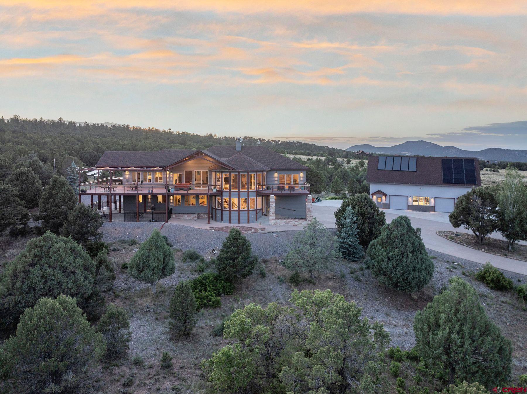 Escape to your own private paradise on over 18 acres of pristine land boasting breathtaking views and unparalleled natural beauty. This expansive property features a spacious main residence with 5 bedrooms, offering ample space for comfortable living for extended family and entertainment. With 4.5 baths and 4930 square feet of livable space, as well as 1693 Square Feet of attached Garage Space, this home provides both luxury and functionality. Step outside your living room of windows, onto the expansive 1565 square feet of deck space, including nearly 1200 feet of retractable covered deck facing south and east, providing the perfect vantage point to admire the stunning vistas of the Cimmaron and Sneffels Mountain Ranges any time of year.  Located atop Log Hill Village in the picturesque town of Ridgway, this property offers convenient access to the area's top amenities. Enjoy world-class skiing at Telluride, just a scenic 45-minute drive away, or indulge in boating and water activities at the nearby Ridgway Reservoir. For golf enthusiasts, the Divide Ranch and Golf Club is just 5 minutes away. The historic town of Ouray, known to be the little Switzerland of America, with world-class ice climbing in winter and off roading in summer is just minutes away.   This property also allows for horses and livestock, a rare find in this area of Loghill Mesa, making it ideal for equestrian enthusiasts as well. The home has been thoughtfully set up with a multitude of systems to make life easier and more enjoyable. From air conditioning, humidification, on demand hot water, expansive Solar System with battery backup, whole house audio System in both the interior and exterior, and heated 3-car garage plus a large fourth bay set up to store a large RV.  Additionally, the owner has thoughtfully included a detached Solar Heated Garage boasting over 2100 Square feet. Currently utilized as a workspace, equipment and car storage, this extra space offers endless possibilities for Boat or Car Enthusiasts. The Detached Garage features a Full Bath and has an additional loft space that could serve as entertainment space for gathering to watch sporting events.   Don't miss this rare opportunity to own a piece of paradise in the coveted Ridgway area, where nature, adventure and luxury seamlessly converge.