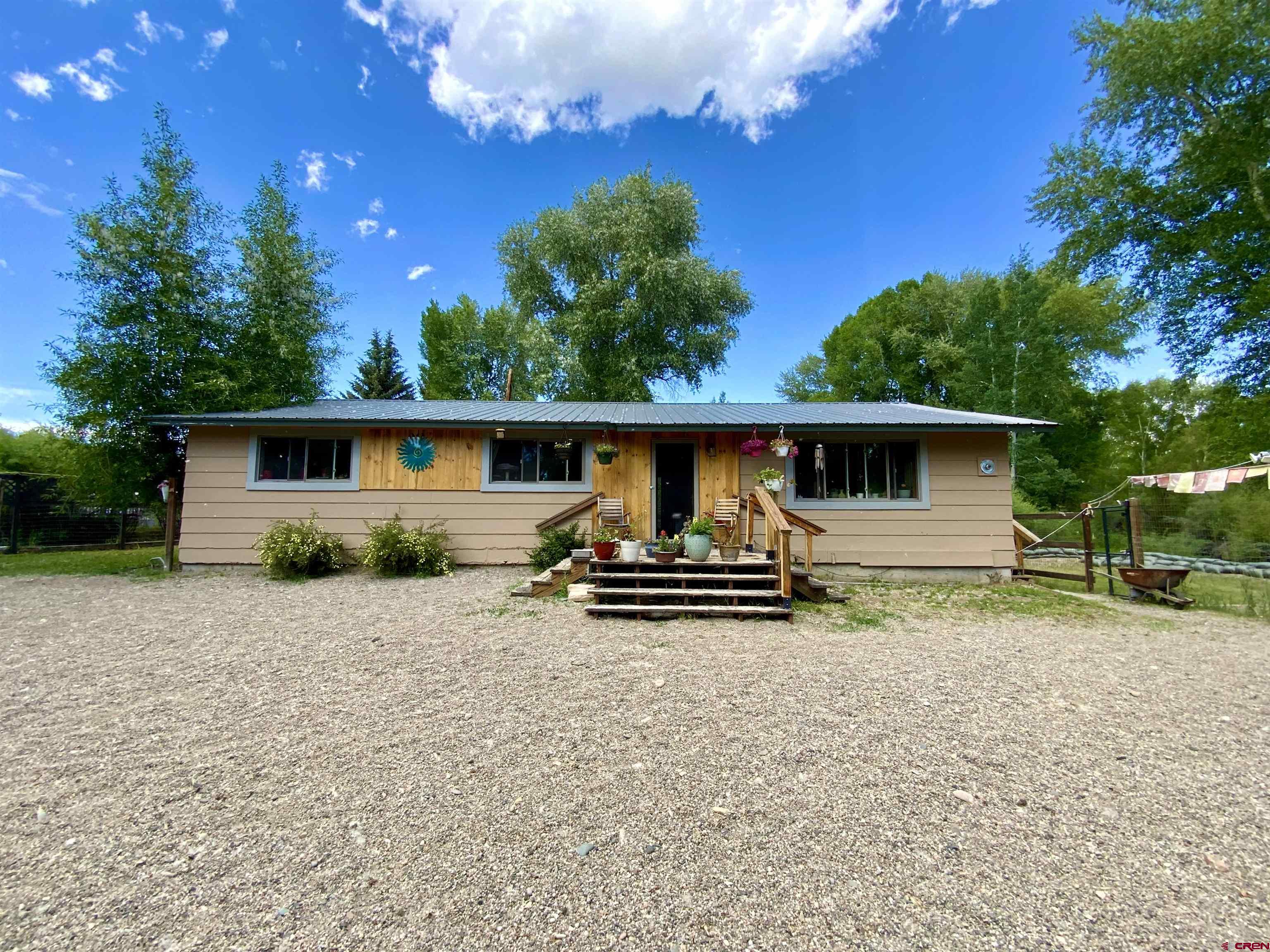 This 3 bedroom/2 bath Gunnison Oasis house is located on .71 acres bordering the Gunnison River Stream and has fully remodeled bathrooms, updated hardwood floors and newer windows and doors.  The house is 1400 square feet and features a large kitchen with stainless steel appliances and copper countertops with a dining area.  West facing living room with large windows lets in tons of natural light.  This is a must see property!