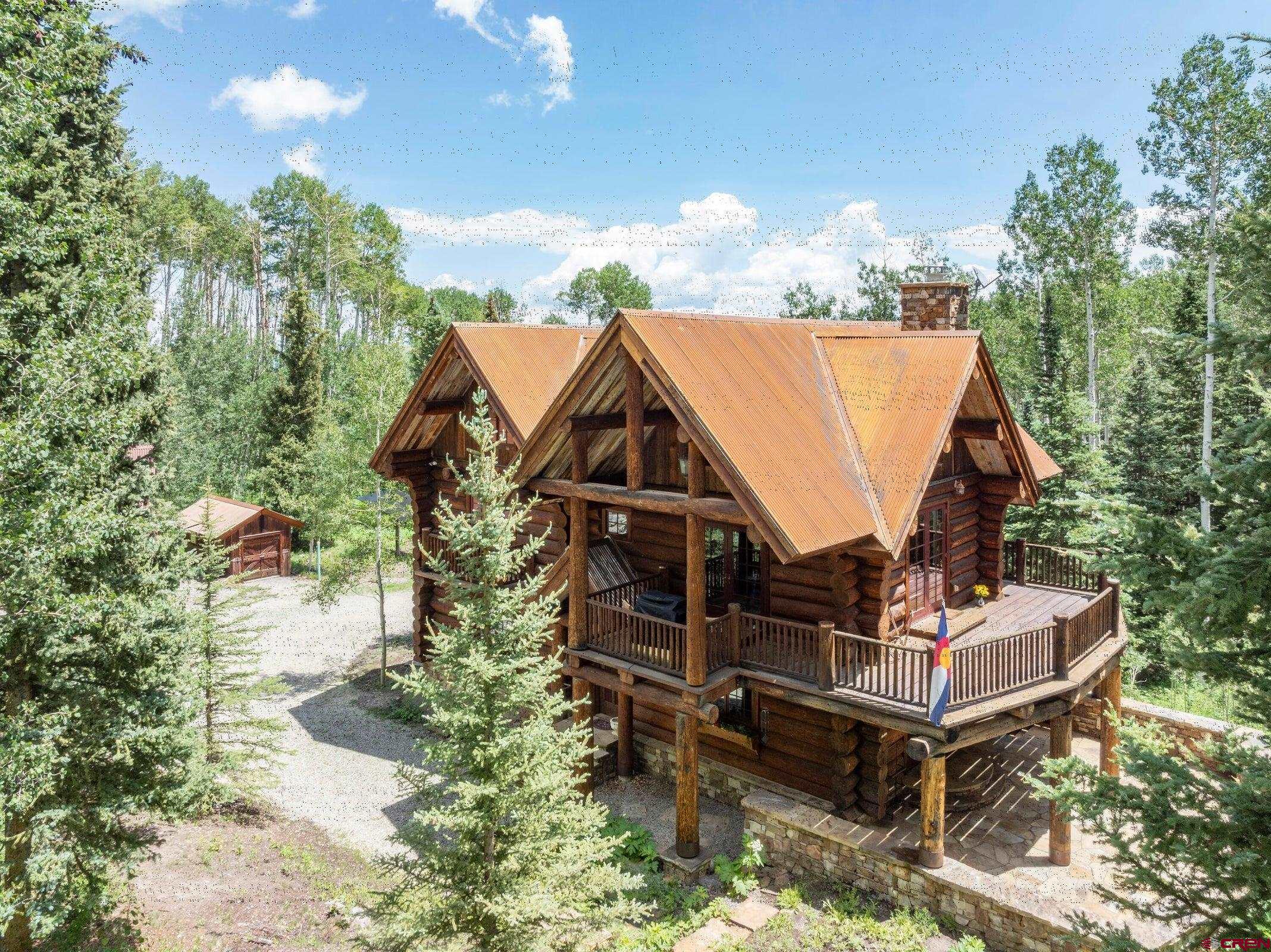 Nestled in the breathtaking beauty of Hastings Mesa, this stunning custom log home offers an unmatched blend of rustic charm and privacy. Imagine waking up each morning surrounded by lush forests, where the serenity of nature seamlessly merges with the comfort of meticulously crafted living spaces. This two-bedroom plus bunkroom and a loft, 3,000-square-foot home, built by Evans Construction, features hand-hewn Swedish cope installation, custom concrete countertops, a solid bronze farm sink, a brand new roof, and a new solar system. The masterful craftsmanship of Steeprock Joinery is evident throughout, with custom cabinetry, woodworking, and metalwork that showcase superior quality and artistry.  Located 33 miles from Telluride and 17 miles from Ridgway, this mountain retreat enjoys private hunting and recreational access to the adjoining Sneffels Wilderness area and the San Juan National Forest. Enjoy hunting, hiking, skiing, Nordic skiing, snowshoeing, and snowmobiling right from your door.  Designed as a multi-generational family retreat and sanctuary for friends and family to gather, the home offers ample private sleeping areas and an abundance of decks and patios, perfect for al fresco dining, star-gazing, or simply soaking in the tranquility. You must come and see this exceptional diamond in the rough for yourself.