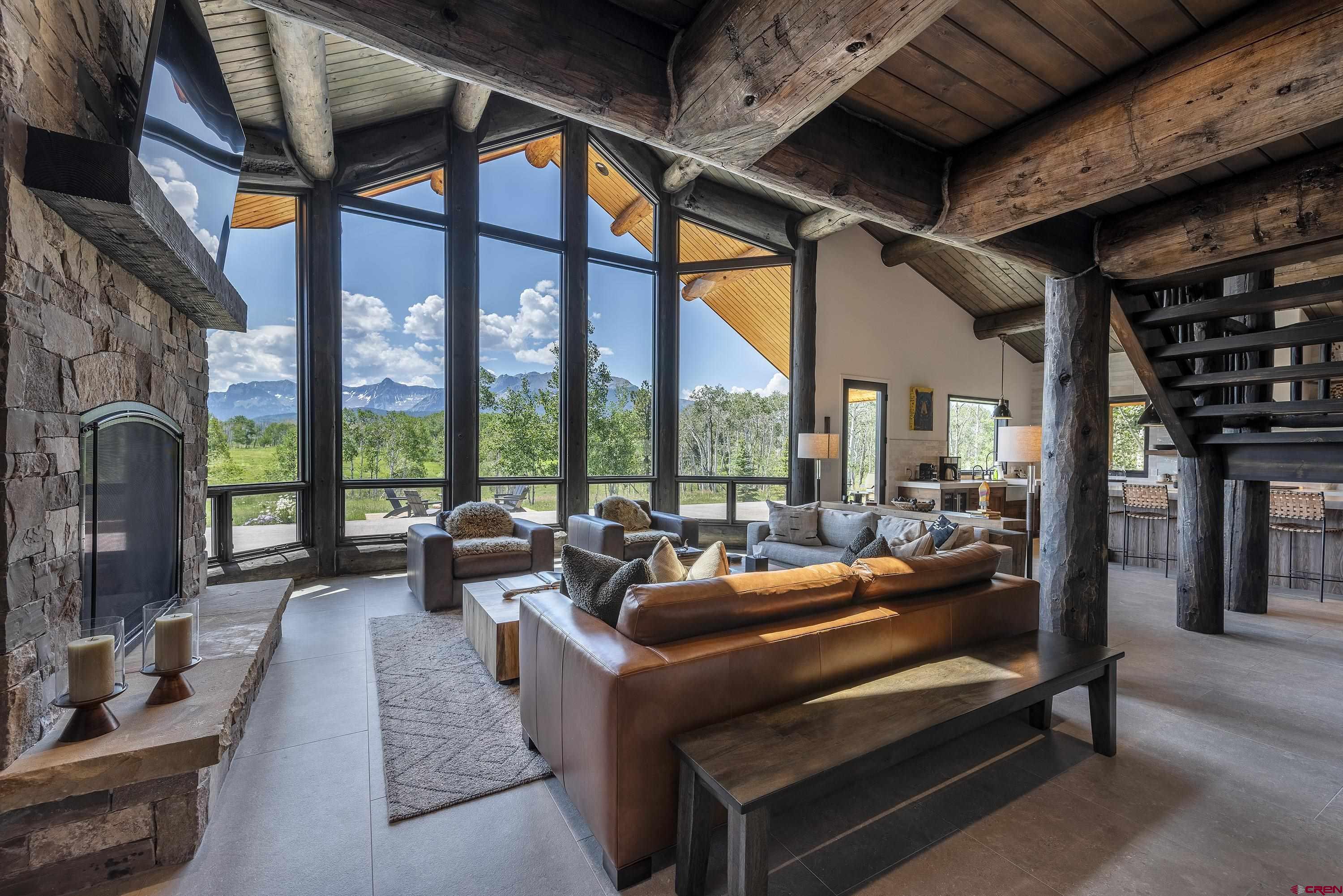 Set on 40 private acres in the San Juan Mountains with sweeping views of the Sneffels Range, this beautifully reimagined home offers a rare combination of privacy, design, and proximity—45 min from Telluride and Montrose, 20-min from Ridgway. Fully remodeled in 2024 down to the studs by Allison Construction, the original builder for Ralph Lauren, the home now reflects a clean mountain-modern aesthetic. It features 4 bedrooms, 3.5 baths, and a thoughtfully designed open floor plan with vaulted ceilings and large picture windows. The remodel added a spacious primary suite and a versatile covered dining/play room. Upstairs includes a second living area, two bedrooms, and a full bath. The Polaris utility vehicle is included and lives in the large, heated, 2-car detached garage.  Outdoor Paradise Centered in an aspen grove that shelters from the wind without sheltering the views, the home offers expansive decks and a propane fire-pit with custom-made artisan steel logs for outdoor enjoyment. The property also features a trail system and an old hunting cabin, perfect for outdoor adventures. Included with the property is a Polaris tractor for traversing the snow.  The large heated detached 2 1/2 car garage and workshop includes a loft that can serve as an office, studio, or extra sleeping space.  Quality Craftsmanship Originally built and recently remodeled by Ralph Lauren's builder, Allison Construction, the home boasts a robust structure with hand-chinked, hand-hewn logs reinforced with stone, beautifully contrasting with the modern interior.  High-End Upgrades The property includes numerous high-end upgrades. Kitchen:  Sub-Zero refrigerator/freezer, Wolf gas stove/oven, Asko dishwasher, built-in water purification system, Ralph Lauren pendant lights, 42-bottle stainless steel wine cooler, 3" thick Caesarstone countertops, built-in Wolf drawer microwave.  Laundry Room:  Maytag commercial technology washer and dryer, built-in cherrywood cabinets, 3" thick Caesarstone countertops, 22" Onyx sink.  General House: Pella windows and doors, two buried 1,000-gallon propane tanks, two 1,200-gallon cisterns, whole house water treatment system, in-floor heat on the lower level, baseboard heat on the upper level, YoLink wireless thermostats, over-sized 65" x 45" arched gas fireplace, new Lochinvar boiler with a 113-gallon sidearm and hot water recirculating pump, motorized Hunter Douglas sunshades in the great room, built-in Hunter Douglas blinds throughout, outdoor surveillance system with cameras, screened enclosure for the outdoor dining porch. Owner's Suite: Glass-enclosed shower, clawfoot steel tub, electric towel warmer, large walk-in closet with built-in cabinets. Please refer to the attached document for a detailed list of many upgrades.   This 40-acre property perfectly blends rustic charm and modern luxury, offering a unique living experience in one of Colorado's most beautiful locations.