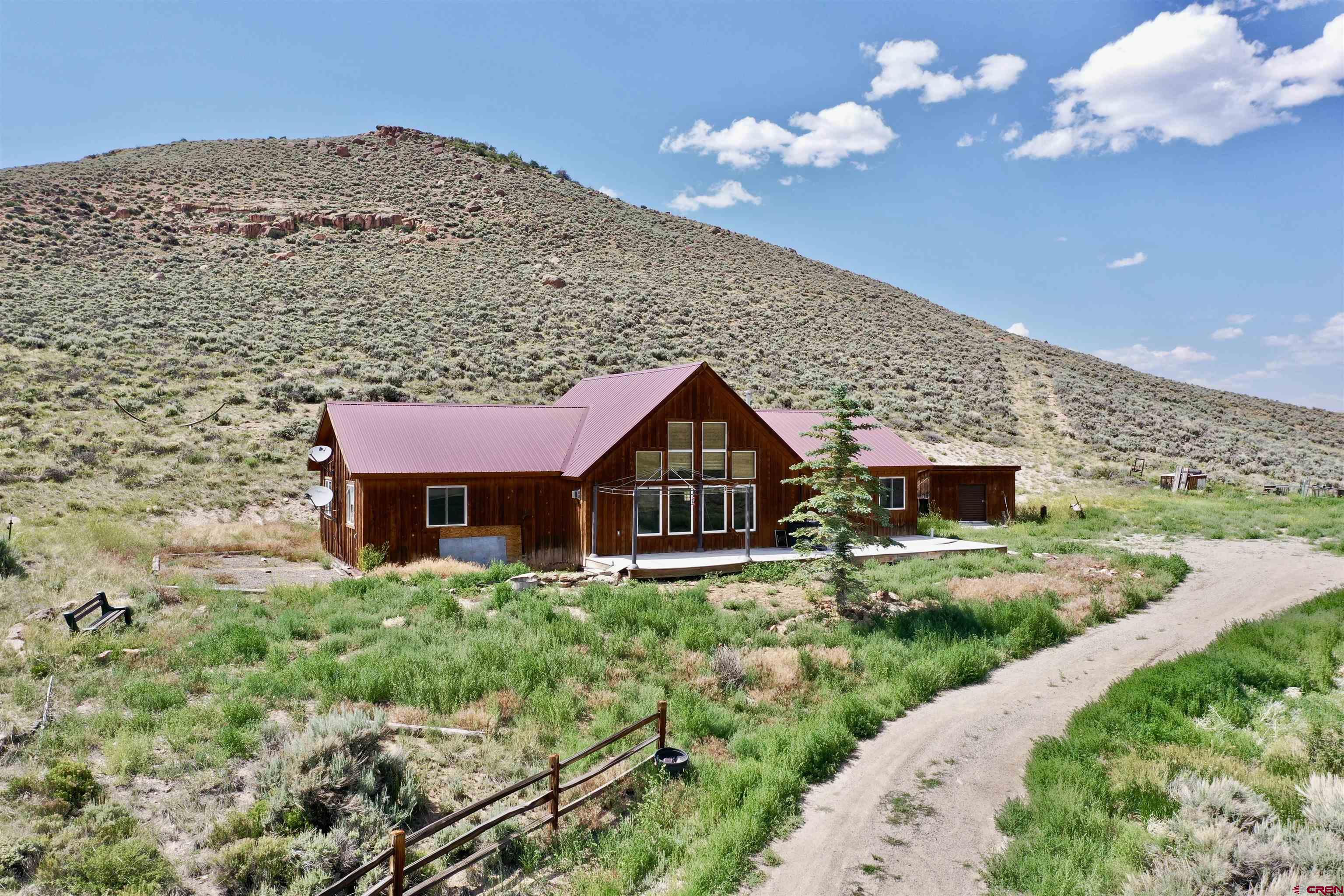 This remarkable 3 bedroom/2 bath home on 34 +/- acres is just minutes away from Blue Mesa lake. This ranch style home has a large central living room with a gas stove and a large kitchen for all your entertaining needs. Primary bedroom has its own gas fireplace with primary on suite bathroom. Primary bathroom has a shower and walk-in closet. The other 2 bedrooms share a full bathroom. Utility and laundry room share the same space. This property is located within hunting unit 66 with easy access to hunting unit 67. This is a no HOA and no covenant property. Don't miss this opportunity on owning a 1,700 plus sqft home on 34 acres.