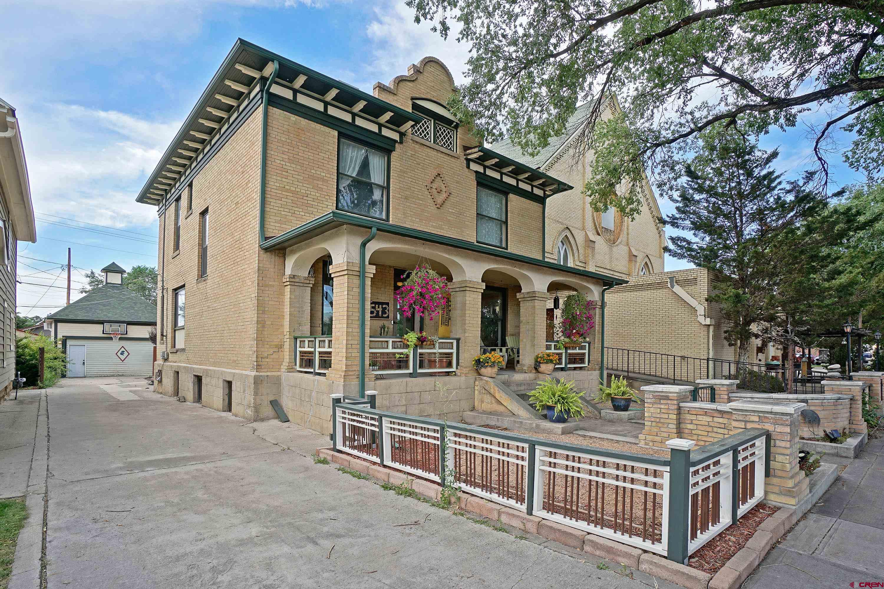Come Experience this Historic Iconic Montrose, Colorado Home!  What does the City of Montrose, Colorado, mean to you? For many, it's the ideal blend of staying local while having the flexibility to explore anywhere. With a temperate climate, Montrose boasts milder summers compared to other parts of the country and winters that feel like a blessing. This inviting environment, along with outstanding air service (both commercial and private) and top-notch medical facilities, draws people to Montrose. Over the past 150 years, individuals have found their unique reasons to call Montrose home. This classic estate home stands as a testament to the charm that has attracted residents to Western Colorado. Two Homes, One Exceptional Property  Situated on a fully developed 6,250 square foot lot, this property includes a stately 3,300 square foot manor, fully remodeled, and a charming guest cottage that has become one of the area's most desirable Airbnb experiences. Every square foot of the lot has been thoughtfully enhanced and lovingly maintained.  A Historic Estate in Montrose  This home is one of the few remarkable properties in the area, joining the ranks of notable buildings like the KP Building (soon to be a boutique hotel), the Townsend Home, the Potato Growers building, the Masonic Temple, and the Methodist Church. Constructed in the year 1900, this "Turn of the Century" home offers a rare glimpse into the past, complete with a carriage house and horse-and-buggy tie-off out front.  The Main Manor  The main home spans three levels of approximately 1,000 square feet each, fully restored with elegant trim, soaring ceilings, oversized windows, and hardwood floors. The rooms are generously sized, showcasing intricate woodwork, tile, and trim, alongside modern fixtures, utilities, and appliances. This is a home where you can always discover something new and special. Upon entering, the intricately designed front yard and porch lead you into a regal entry area with views of the upper level, the kitchen core, and the beautiful parlor and dining room. The kitchen, with its granite counters, top-notch cabinetry, and spacious layout, serves as a true heart of the home. Beyond the kitchen, you'll find a laundry and specialty room that leads to the beautifully landscaped backyard. The lower level, accessible from the side yard, offers additional housing opportunities with an open layout, perfect for guests or family members, and even as an income stream. The bathroom and fireplace on this level ensure a cozy and comfortable atmosphere. The upper level features three oversized bedrooms, a full bath, and a luxurious master suite with a large walk-in closet, elegant soaking tub, and oversized tiled shower.  The Guest Cottage  The backyard, designed for relaxation and gatherings, is shielded from the late-day sun and features beautiful paths, stone walls, and a lovely greenhouse for both plants and projects. The former carriage house has been converted into a two-level ADU with two bedrooms, an inviting bath, and soaring ceilings. This space can serve as an office, guest home, workout studio, or income-generating rental.  Experience Montrose's Rich History  Are you searching for something special? Something that celebrates the rich history and charm of Montrose and Western Colorado? Come see this elegantly designed and fully restored home and become the next part of its legacy in Montrose.