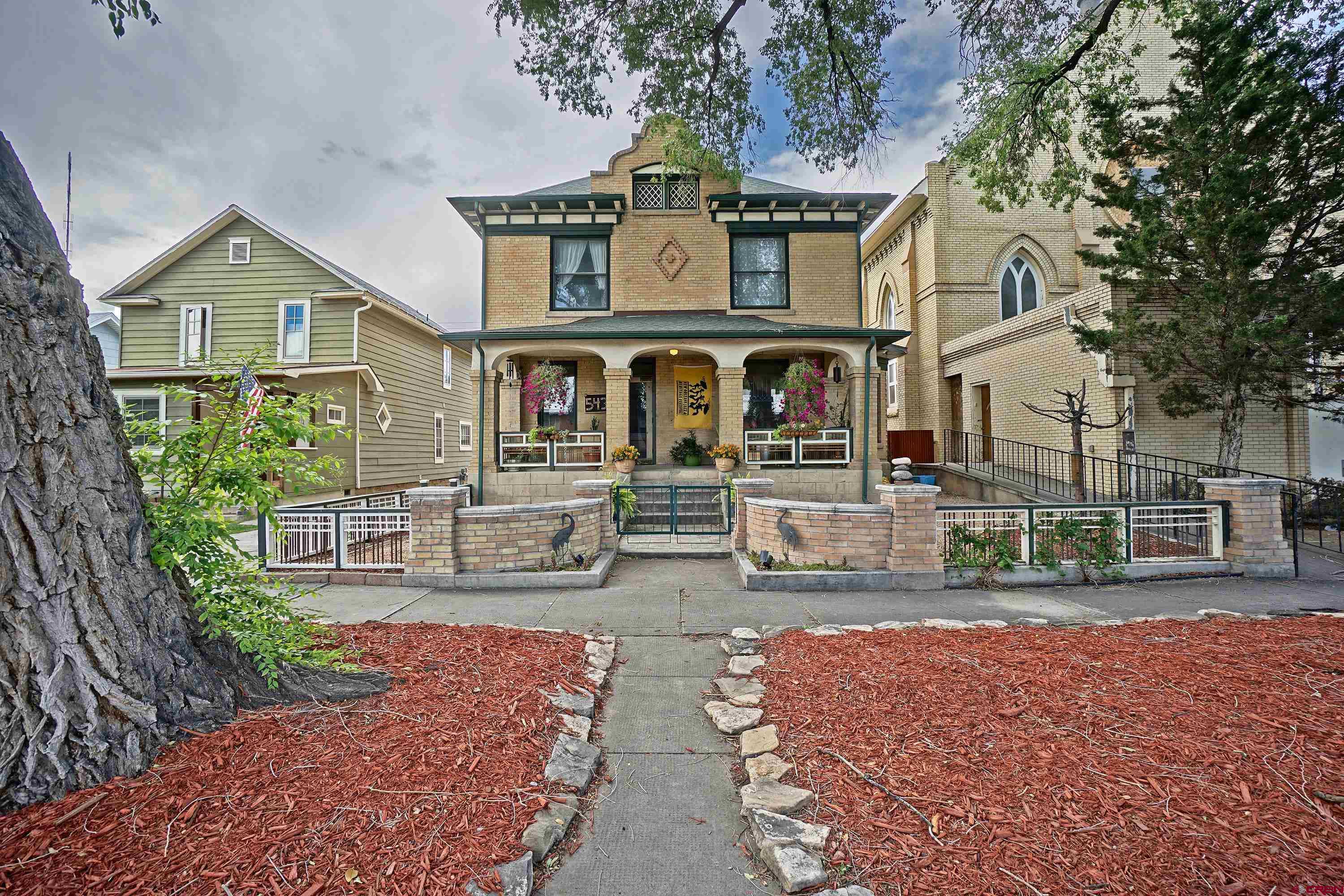 Come Experience this Historic Iconic Montrose, Colorado Home!  What does the City of Montrose, Colorado, mean to you? For many, it's the ideal blend of staying local while having the flexibility to explore anywhere. With a temperate climate, Montrose boasts milder summers compared to other parts of the country and winters that feel like a blessing. This inviting environment, along with outstanding air service (both commercial and private) and top-notch medical facilities, draws people to Montrose. Over the past 150 years, individuals have found their unique reasons to call Montrose home. This classic estate home stands as a testament to the charm that has attracted residents to Western Colorado. Two Homes, One Exceptional Property  Situated on a fully developed 6,250 square foot lot, this property includes a stately 3,300 square foot manor, fully remodeled, and a charming guest cottage that has become one of the area's most desirable Airbnb experiences. Every square foot of the lot has been thoughtfully enhanced and lovingly maintained.  A Historic Estate in Montrose  This home is one of the few remarkable properties in the area, joining the ranks of notable buildings like the KP Building (soon to be a boutique hotel), the Townsend Home, the Potato Growers building, the Masonic Temple, and the Methodist Church. Constructed in the year 1900, this "Turn of the Century" home offers a rare glimpse into the past, complete with a carriage house and horse-and-buggy tie-off out front.  The Main Manor  The main home spans three levels of approximately 1,000 square feet each, fully restored with elegant trim, soaring ceilings, oversized windows, and hardwood floors. The rooms are generously sized, showcasing intricate woodwork, tile, and trim, alongside modern fixtures, utilities, and appliances. This is a home where you can always discover something new and special. Upon entering, the intricately designed front yard and porch lead you into a regal entry area with views of the upper level, the kitchen core, and the beautiful parlor and dining room. The kitchen, with its granite counters, top-notch cabinetry, and spacious layout, serves as a true heart of the home. Beyond the kitchen, you'll find a laundry and specialty room that leads to the beautifully landscaped backyard. The lower level, accessible from the side yard, offers additional housing opportunities with an open layout, perfect for guests or family members, and even as an income stream. The bathroom and fireplace on this level ensure a cozy and comfortable atmosphere. The upper level features three oversized bedrooms, a full bath, and a luxurious master suite with a large walk-in closet, elegant soaking tub, and oversized tiled shower.  The Guest Cottage  The backyard, designed for relaxation and gatherings, is shielded from the late-day sun and features beautiful paths, stone walls, and a lovely greenhouse for both plants and projects. The former carriage house has been converted into a two-level ADU with two bedrooms, an inviting bath, and soaring ceilings. This space can serve as an office, guest home, workout studio, or income-generating rental.  Experience Montrose's Rich History  Are you searching for something special? Something that celebrates the rich history and charm of Montrose and Western Colorado? Come see this elegantly designed and fully restored home and become the next part of its legacy in Montrose.