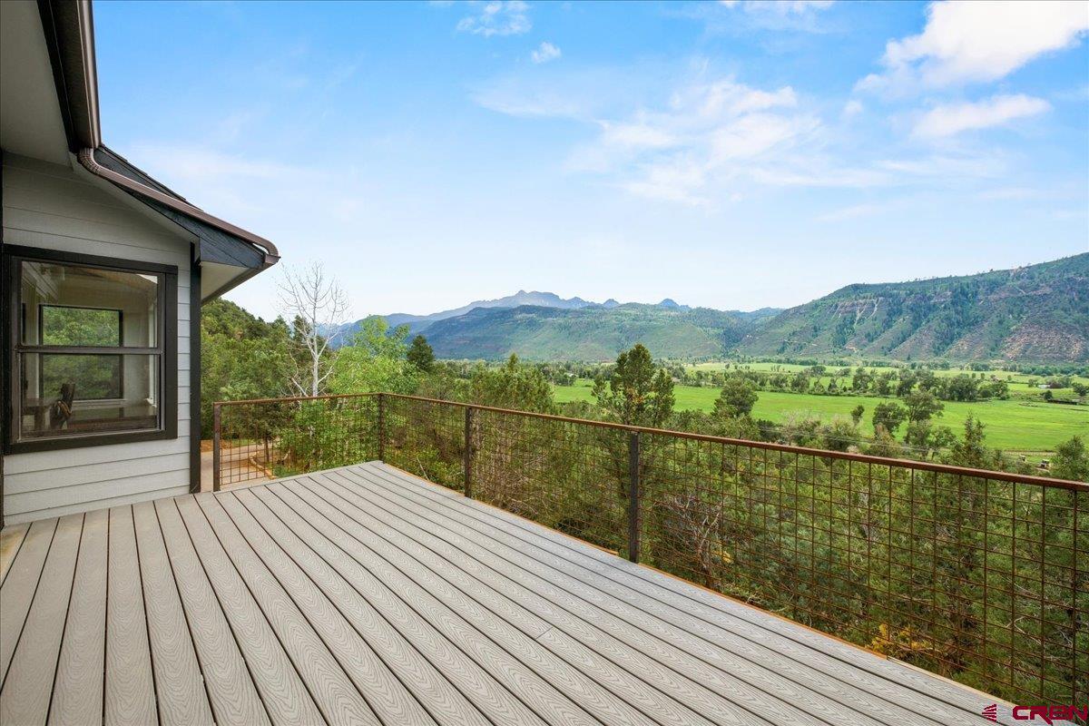 Nestled in the stunning landscape of Ouray County, this exceptional home sits on over two acres, offering breathtaking views of the Ridgway Valley and San Juan Mountains. Ideally located between Ridgway and Ouray, just off Hwy. 550, it provides both convenience and tranquility.  The home features three private bedroom suites, each with its own bath, ensuring comfort for all. A spacious downstairs family room offers plenty of space to gather and relax. Step outside to enjoy the fresh mountain air from the patio or expansive deck, both showcasing spectacular vistas.  For car enthusiasts, the detached garage is a dream—complete with built-in workbenches, air compressor tubing, and a top-tier drainage system. Overlooking sprawling ranch lands, this property is a peaceful retreat with unmatched scenery. Don’t miss the chance to make it yours!