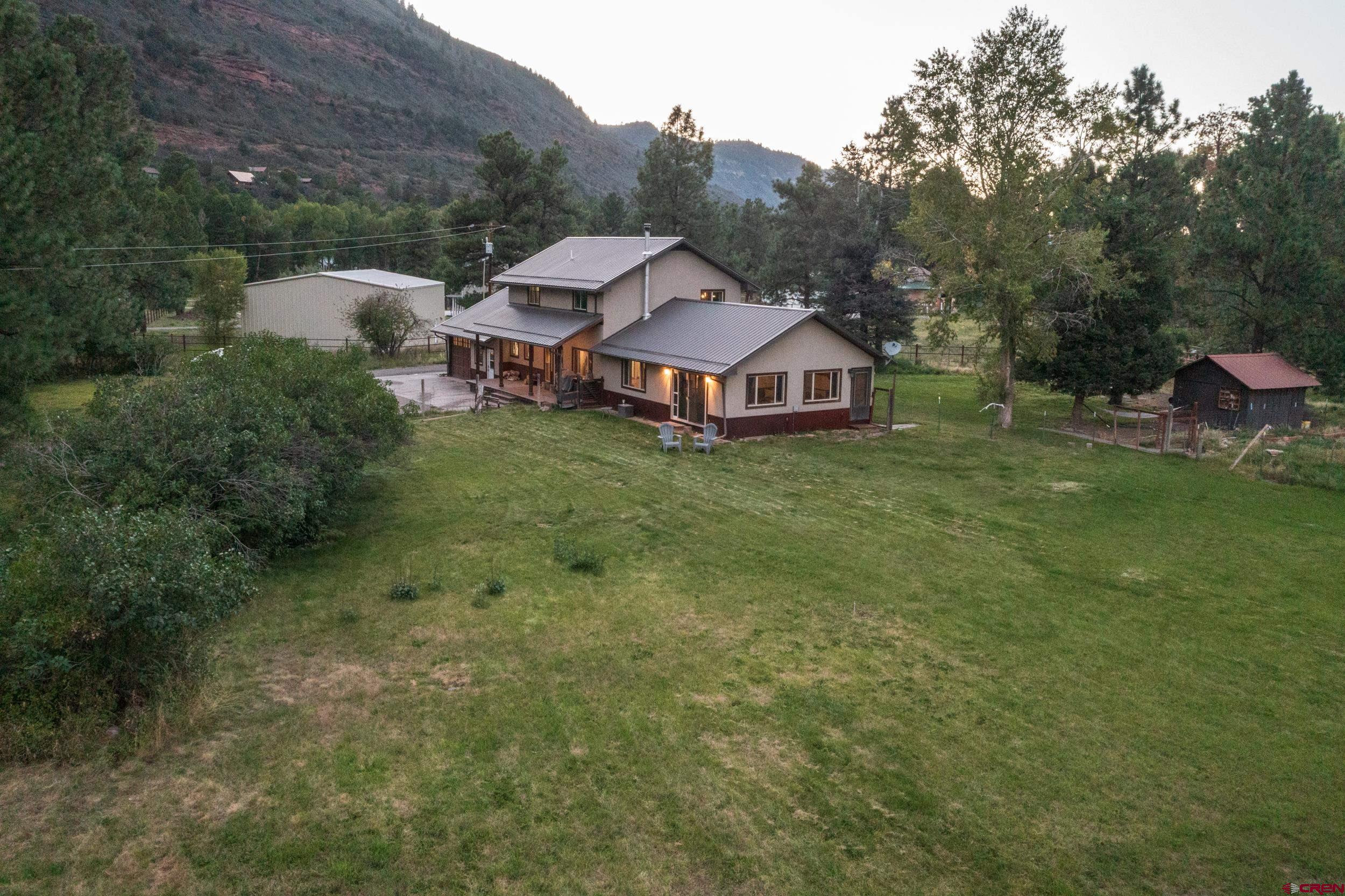 BACK ON THE MARKET!  Seller found a new home and is ready to sell!  Nestled between Ridgway and Ouray, Colorado, this stunning 4-bedroom, 3-bath home is the ultimate mountain escape, cherished by locals for its peaceful charm. Fully remodeled and move-in ready, the home blends modern luxury with rustic elegance. Spacious, light-filled living areas, an updated kitchen, and bathrooms offer both comfort and style.  This home is as secure as it is beautiful, with recent upgrades including a new roof (2016), energy-efficient windows (2019), a state-of-the-art on-demand water heater (2022), and a new furnace (2023). The exterior boasts fresh stucco (2019), while inside, the stylish LVP flooring was installed recently. For electric vehicle owners, a 50-amp charger in the heated garage adds convenience, along with the extra tall garage door, storage and work area.  Outside, the peaceful backyard offers a perfect retreat with sweeping views of the surrounding landscape. Plus, with coveted water rights, this property offers a rare blend of practicality and luxury. Whether you’re seeking adventure or solitude, this home is your gateway to the best of Colorado living.