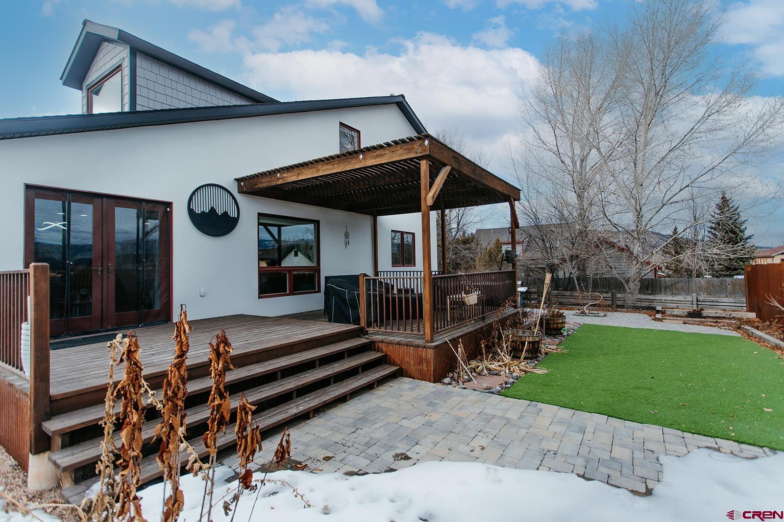 Stunningly updated home nestled in the picturesque valley at the base of the San Juan Mountains, this beautifully updated home in Ridgway offers a modern aesthetic and exceptional living. The gorgeous kitchen boasts a new granite waterfall island with a prep sink and seating space, a stylish full-height backsplash, and brand-new stainless steel appliances, including a gas range with an exterior-vented stainless hood, refrigerator, and dishwasher. Designed for entertaining, the open floor plan flows effortlessly from the kitchen to the dining and living areas, featuring vaulted ceilings and an exposed steel beam, leading to a loft above with sleek new steel railings. Enjoy refinished hardwood floors in the dining and living rooms, paired with easy-maintenance tile in the kitchen, entry, and hallway. The main-level master bedroom exudes comfort with plush carpeting, a ceiling fan, dual closets, and an en-suite bathroom showcasing a double vanity and a luxurious zero-threshold tiled shower with a glass door. A powder room with plaster walls and a redesigned laundry area (washer and dryer included) complete the main level. Upstairs, discover a bright loft space, two spacious bedrooms with ceiling fans, and a beautifully appointed full bathroom featuring a tiled shower with a glass door, a freestanding soaker tub, and a double vanity. An additional room offers endless possibilities as a studio, craft room, or playroom.  Stay connected with internet via Clearnetworx and new outlets with USB ports in every bedroom. Step outside to a spacious covered patio with extended concrete and a freshly stained deck—perfect for relaxing in the included hot tub while enjoying the fresh Colorado air. The fully fenced yard provides privacy, and the attached two-car garage features expanded driveway space and extra room on the side.  Enjoy being conveniently located within walking distance to Ridgway’s restaurants, market, and town park. Experience Colorado’s finest outdoor lifestyle all around you with the Ouray Hot Springs 15 minutes up the valley and world-class skiing in Telluride under an hour’s drive. Paddleboard at Ridgway Reservoir, fish the gold-medal waters of the Gunnison River, or explore endless hiking, biking, and jeep trails in every direction.  Easily connect elsewhere via the Montrose Regional Airport 30 minutes north. This Ridgway gem is your gateway to a life of adventure and beauty—don’t miss out!