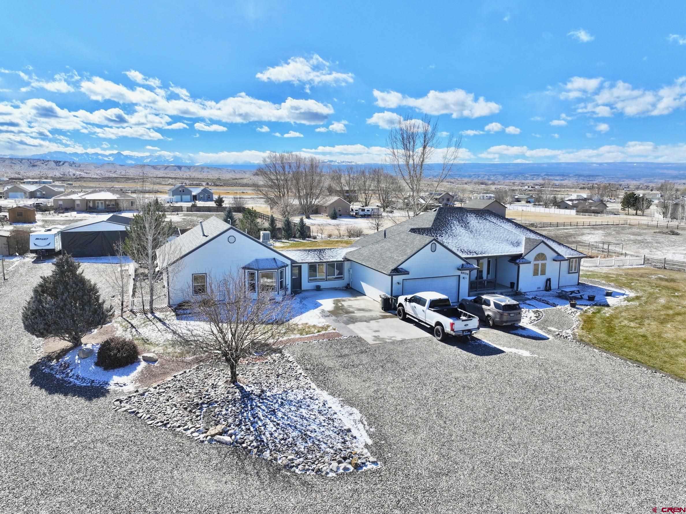 Beautifully updated ranch-style home with guest house and breathtaking San Juan mountain views!  This turn-key property offers a perfect blend of comfort, convenience, and stunning scenery, with modern upgrades, a spacious layout, and a peaceful setting. Located on a paved road in a quiet neighborhood, the home includes ample irrigation water through the HOA (under $250 per year!) and reliable high-speed internet provided by Elevate.  The main house welcomes you with a large living room featuring a cozy wood-burning fireplace and south-facing windows that fill the space with natural light. The kitchen is designed for both functionality and style, with an eat-in bar, ample cabinet and countertop space, newer stainless-steel appliances, and access to a back deck—ideal for outdoor gatherings. A half bath is conveniently located near the garage, along with a separate laundry room.  The primary suite serves as a private retreat, featuring double sinks, a soaking tub, a separate shower, a walk-in closet, and an additional closet for extra storage. Two guest bedrooms share a Jack-and-Jill bathroom, and hard surface flooring runs throughout the home for easy maintenance.  Connected to the 2-car garage by a breezeway is the guest house. This charming one-bedroom home includes a ¾ bath, a full kitchen, a pantry/storage closet, and two living spaces. The guest house has its own back deck with direct access to the backyard.  The backyard is an entertainer’s dream, with custom landscaping, a flagstone patio, a fire pit area, and a hot tub. The fully fenced yard offers privacy and space to relax. Additional features include a large 42’x35’shop with an attached storage room and mower garage door, a separate storage shed, a playhouse, and a timed irrigation system with multiple zones for easy upkeep.  With its versatile living spaces, modern updates, and spectacular mountain views, this property is ready to welcome you home!