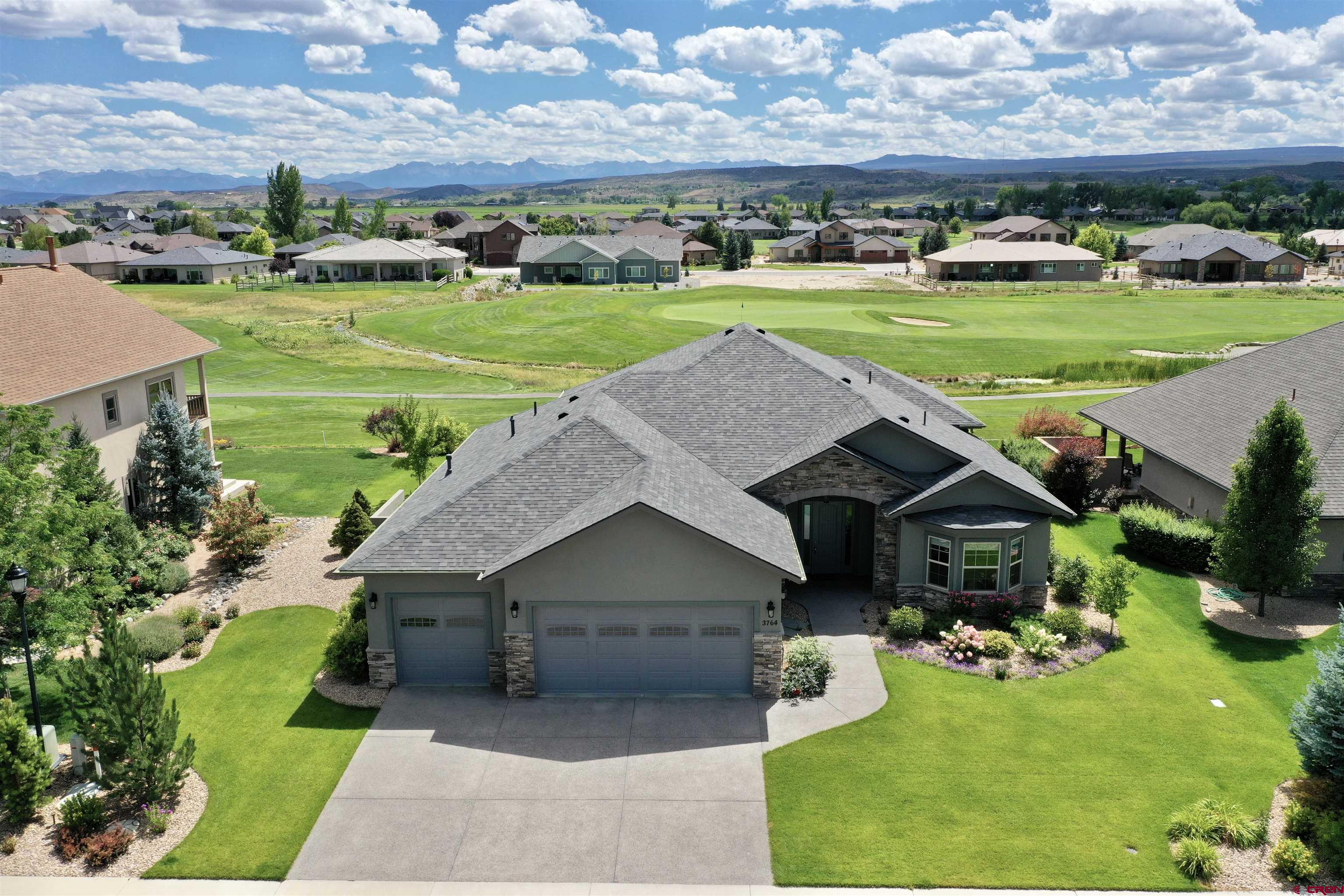 Come take a look at this like-new beautiful and custom built ranch style home in Cobble Creek! This home is sure to impress and hits the mark on location, layout, and in the finer custom details throughout. Upon arriving at the home the custom details start to shine immediately starting at the driveway, the exposed aggregate concrete provides durability and slip resistance during those colder months. Out front and to either side of the oversized 3-car garage you'll note the manicured landscaping. Inside the open foyer you've got storage and your eye will catch the beautiful engineered wood floors throughout which will lead you to the views straight through the home of the 2nd Tee and the stunning San Juan Mountain range! Just beyond the entryway the hallway leads to each side of the home. Two bedrooms and a full bath on one side and a guest powder room, laundry room, and primary suite to the other side of the home. Your family, friends and any other guests can enter straight into the large and open main living area that's laid out very nicely helping to answer that common question of 'what goes where' in an open floorplan. The living room section has a gas fireplace and large patio sliding glass door. Across the room there is space for nearly any size dining table and accompanying furniture which then flows seamlessly into the large kitchen offering an abundance of storage with custom cabinetry, an oversized wraparound bar, and granite countertops. The additional standout feature of this main great room are the large southern windows throughout that maximize the mountain views and open space provided by the golf course. The primary suite offers direct patio access, south-facing views, custom tile work in an oversized dual-head shower and of course a walk-in closet and double vanity with LED backlit mirrors. The list goes on and on with this property! Call today for your private showing so you can appreciate the custom craftsmanship. Enjoy the view.