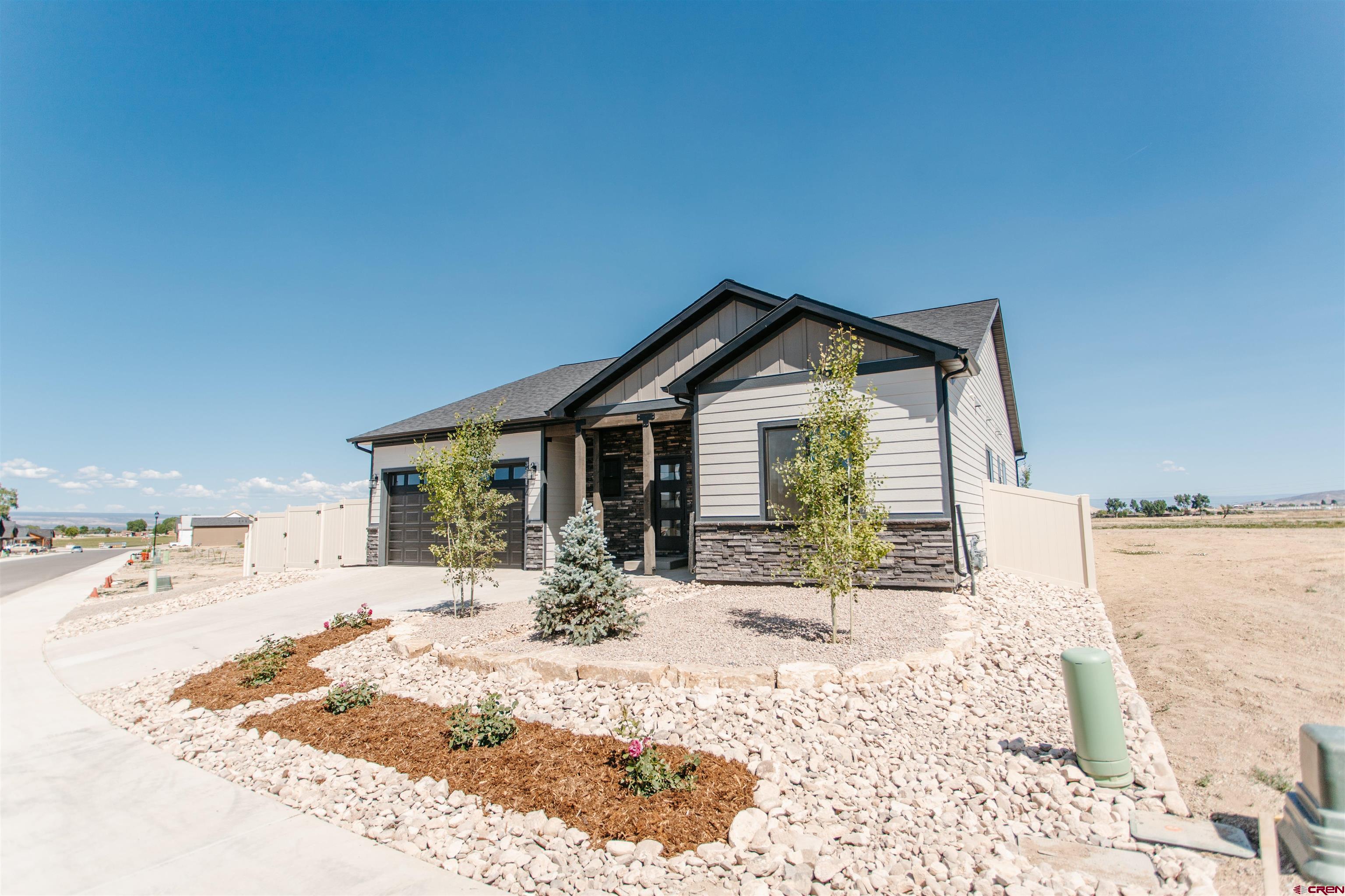 Completed new construction with landscaping in front and back yards and with backyard fence. Thoughtfully designed for effortless living all on one level, the Grand Teton 1808sf model features a split floor plan of 4 bedrooms and 2 baths with an elegant open-concept living space with vaulted ceiling, ceiling fan and gorgeous stone-accented gas fireplace with a beautiful wood mantel.  The living and dining room are open to the gourmet kitchen adorned with upgraded painted cabinetry with soft-close doors and drawers, taller upper cabinets, quartz counters, a stylish tiled backsplash, under-cabinet lighting, dimmer switch on the island pendant lights, TWO pantries and a large kitchen island perfect for entertaining. A premium appliance package includes a stainless steel gas range/oven, refrigerator, dishwasher and microwave. The spacious master suite boasts a vaulted ceiling with a ceiling fan, a beautifully tiled master shower with a glass shower door, a separate bathtub, two sink vanity, private toilet, and a generous walk-in closet. Laundry room offers extra cabinets and countertop with washer and dryer also included, plus there's tons of storage space with two large coat closets and hallway linen closet.  Extra space is also provided in the 2-car garage with one bay extended providing room for workout area, workshop, toys or storage. Designed with energy efficiency in mind, this home includes forced air gas heating, central air conditioning, an on-demand hot water heater, and a radon mitigation system for peace of mind. Outdoor living is enhanced with a covered front porch and covered back patio, with extended concrete from the driveway all the way to the back patio for added convenience.  Added curb appeal with upgraded board and batten accent siding. Brand-new and walk-in ready - both inside and out - in beautiful Montrose! Make this wondeful new home your next home!
