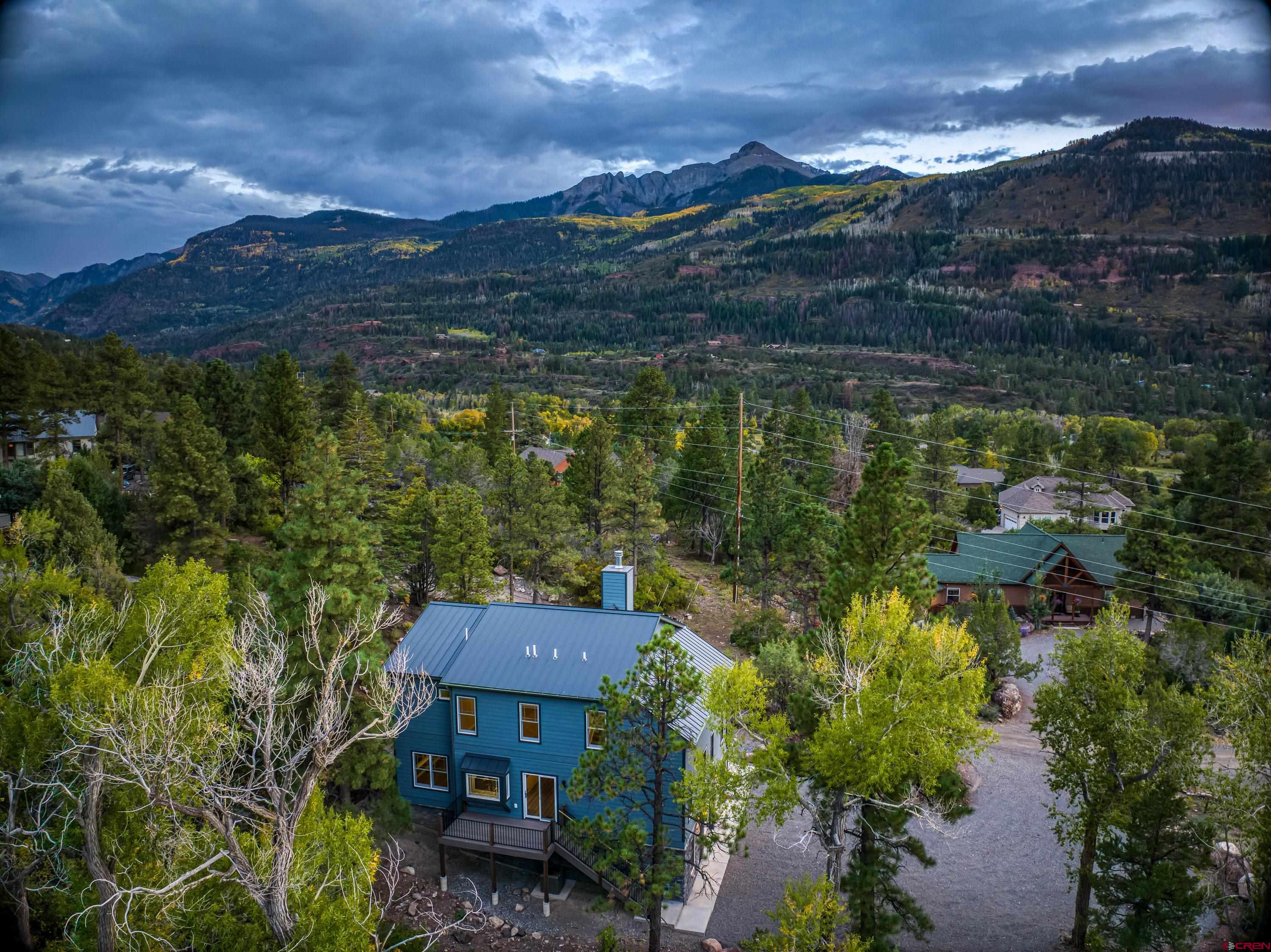 Welcome to your dream mountain home in Ouray County! This brand-new, never-lived-in home sits on half an acre, backing up to Cutler Creek and the San Juan National Forest—giving you endless outdoor adventure right in your backyard.  This 3-bedroom, 2.5-bathroom home features two offices, a formal dining room, and a bonus room—perfect for remote work or extra space.  Built for comfort and efficiency, enjoy solar power credits, dual-zone heating & A/C, a large wood-burning fireplace, and a durable metal roof.  Located just 5 minutes to Ouray and Ridgway, inside the Ouray School District, and only 40 minutes to Telluride and Montrose. The HOA is just $250 a year, covering road maintenance, tree inspections, and access to the cave water system for landscaping and fire mitigation.  With breathtaking views and a 50-amp camper hookup, this home is ideal for families or a high-performing vacation rental"