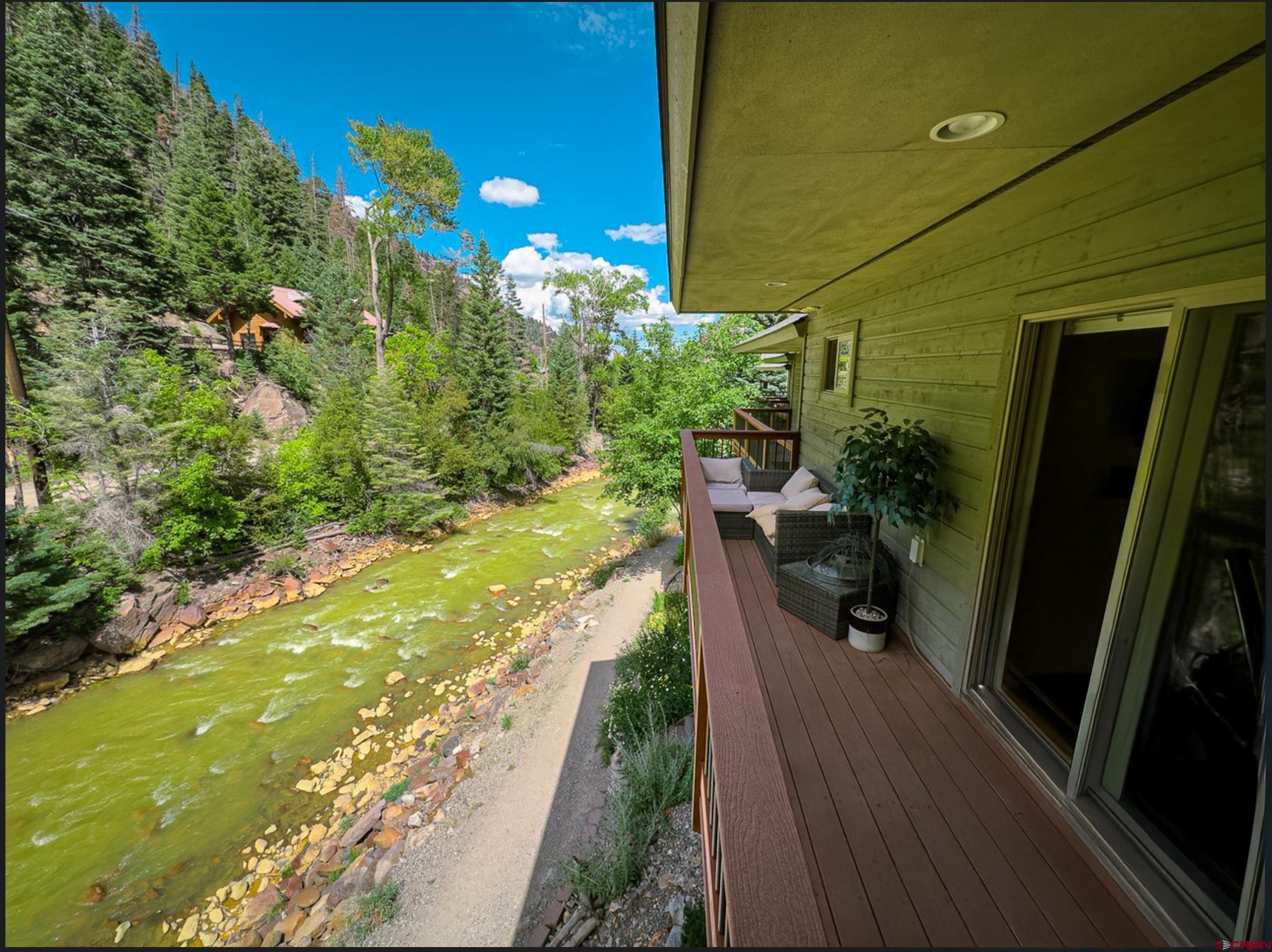 Luxury Riverside Townhome in Ouray, Colorado – Prime for VRBO/Airbnb Rental and a Potential Money Maker  This stunning 3-bedroom, 2-bathroom townhome offers 1,714 square feet of thoughtfully designed living space, combining modern elegance with the natural beauty of Ouray, Colorado. Situated directly on the Uncompahgre River, this property provides private access for walking and relaxation, with the peaceful sounds of the river just 30 feet from the back deck. With breathtaking mountain views, this home is an ideal retreat and a lucrative short-term rental opportunity for VRBO or Airbnb.  The beautifully designed kitchen features granite countertops, a designer backsplash, soft-close cabinets and drawers, and stainless steel Whirlpool appliances. Under-cabinet LED lighting on dimmers enhances the ambiance, while four lazy Susans maximize storage. Bamboo-engineered hardwood floors run throughout the home, complementing the custom pulls on kitchen and bath cabinetry. The upper level boasts soaring vaulted ceilings in the kitchen, adding to the sense of spaciousness, while the lower level offers 8-foot ceilings for a cozy yet open feel.  Enjoy both front and back decks constructed with durable Trex boards and aluminum railings, offering unobstructed mountain and river views. The back deck is the perfect place to relax and watch wildlife, with a near-constant breeze off the river keeping the home naturally cool during the summer months. The included Pottery Barn solid wood mantle, entryway furniture, and custom shelving in the separate laundry room add style and functionality.  Additional features include a heated and insulated one-car garage, custom panel blinds for privacy, and a built-in fire suppression system with ceiling-mounted sprinklers for safety. A dedicated laundry room, conveniently located near the kitchen, includes a washer and dryer.  Located within walking distance of the Ouray Hot Springs Pool and Main Street, this townhome is positioned for both convenience and adventure. Whether you are seeking a full-time residence, vacation getaway, or investment property, this home offers an unbeatable combination of luxury, location, and income potential. Schedule your private tour today to experience this exceptional riverfront townhome in the heart of Ouray.
