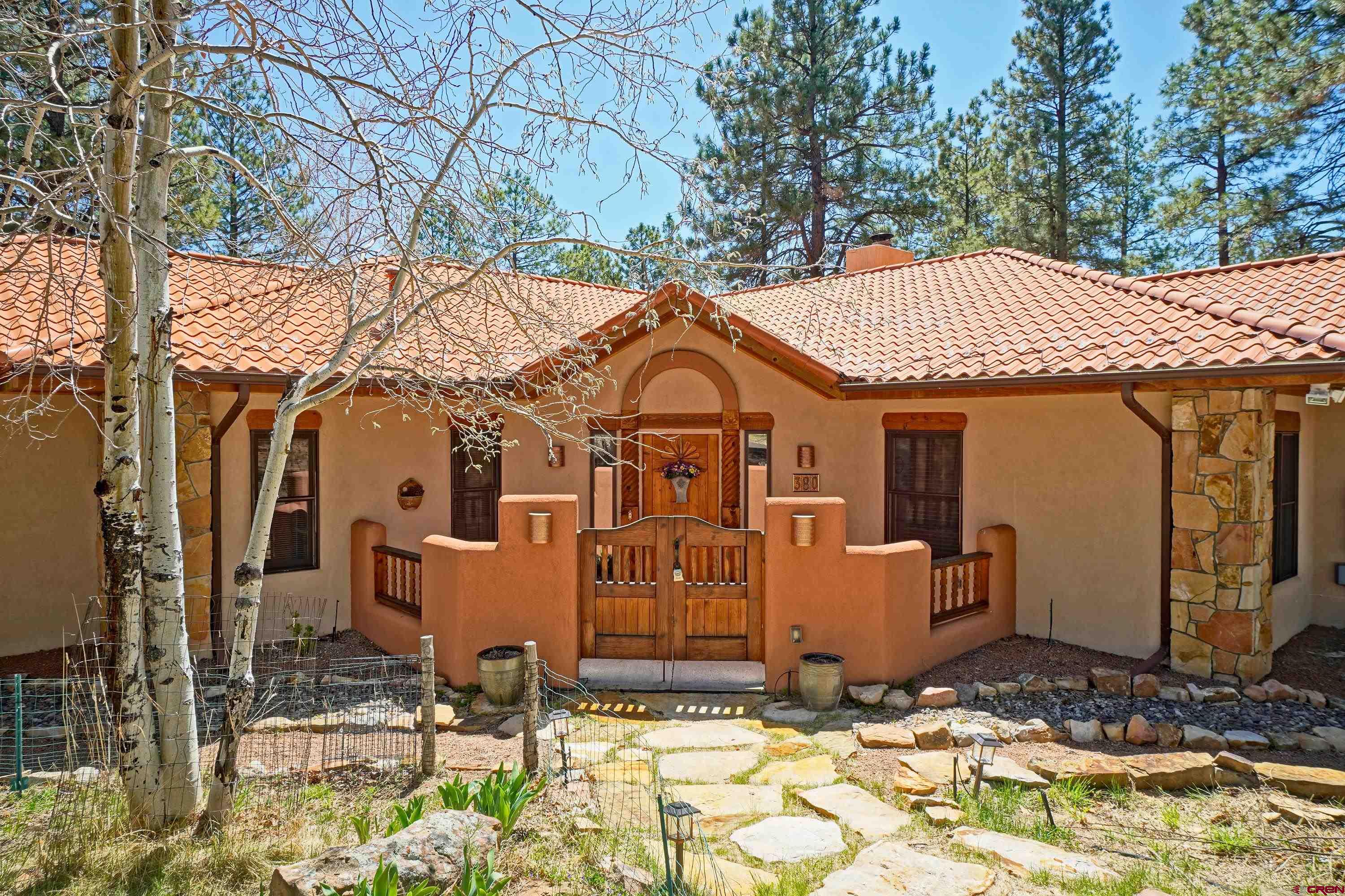 Your Colorado Mountain Dream Home Awaits! Imagine waking up to breathtaking mountain views, surrounded by towering pines and crisp alpine air. This stunning mountain retreat in Divide Ranch and Club, Ridgway, Colorado, offers the perfect blend of rustic elegance and modern luxury. Whether you’re drawn to golfing, hiking, biking, skiing, or simply enjoying the peace of the San Juan Mountains, this home is designed for your ideal Colorado lifestyle.  Built by some of the area’s most skilled artisans, this single-level home has been meticulously upgraded by its current owners. The rich Saltillo tile floors, handcrafted Santa Fe doors, and custom cabinetry are complemented by high-grade granite countertops, new lighting, inset copper accents, and fully updated bathrooms. A chef’s dream, the gourmet kitchen features fully renovated and new kitchen appliances, including a new induction cooktop, double convection ovens, a high-end refrigerator, and a three-level dishwasher—perfect for preparing meals after a day on the slopes or the golf course.  Located next to one of the most coveted holes on Divide Ranch and Club’s championship golf course, this home offers the best of mountain living with a golf-course lifestyle. Spanning over 2,600 square feet, plus nearly 800 square feet of outdoor patios and living space, the thoughtful layout maximizes indoor-outdoor enjoyment. The enclosed courtyard entrance sets a welcoming tone, leading into a grand living space with soaring tongue-and-groove ceilings and exposed beams. The south-facing living room features a stunning kiva-style fireplace with built-in wood storage—both functional and charming.  The primary suite is a private sanctuary with a fireplace, spa-like bath with a soaking tub, an oversized walk-in shower, and a spacious walk-in closet. Step outside onto the expansive rear deck and patio, where you can unwind in the included hot tub and soak in the unparalleled mountain scenery. Two additional bedrooms offer comfortable accommodations for guests or home office space.  With fully maintained year-round access, a newly resurfaced paved circular driveway, and a heated garage, this home is designed for effortless living in all seasons. Just a short drive from Ouray’s hot springs, Ridgway’s vibrant downtown, and Telluride’s world-class skiing, this is the ultimate home base for adventure and relaxation.  Don’t miss this rare opportunity to own a meticulously maintained, move-in-ready home in one of Colorado’s most desirable mountain communities. Schedule your private showing today and start living your Colorado dream!