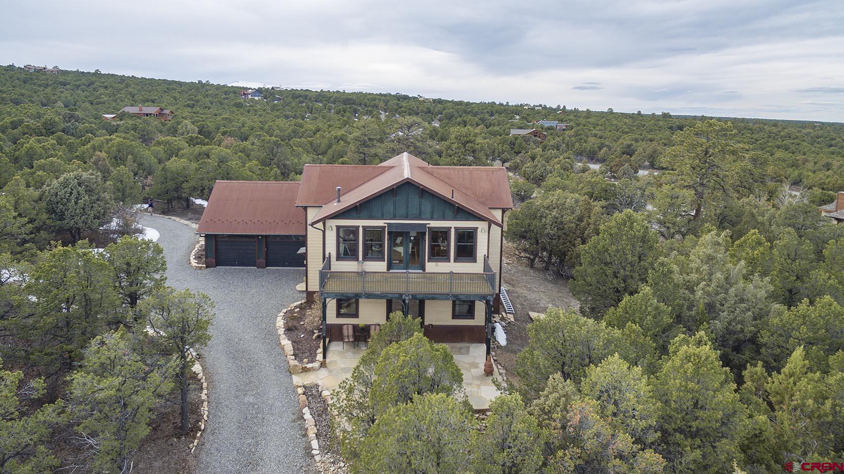 This exceptional home on 2+ treed acres affords great mountain views and privacy. It has been meticulously maintained and is in excellent condition. The dramatic entry with cathedral ceilings is flooded with natural light from numerous south facing windows and leads up to the main living area. The custom iron railing is just one of many quality, craftsman features in the house. The open floor plan upstairs includes the kitchen, dining area and living room. Great Cimarron views, the east facing deck, beautiful cherry wood floors and a gas fireplace make this the great room! The kitchen has custom cabinets and granite counter tops. Of the four bedrooms, the upstairs and one down are both master bedroom size with large baths and jetted tubs. The other downstairs bedrooms could be used as offices. There is a large storage space off of the upstairs bedroom. A mud room provides access to the roomy garage. There is a nice flagstone patio off of the downstairs bedroom. The landscaping is xeriscaped with hardy perennials for an attractive entrance with minimal care. The driveway is circular and there is plenty of room on the west side of the garage for an RV.