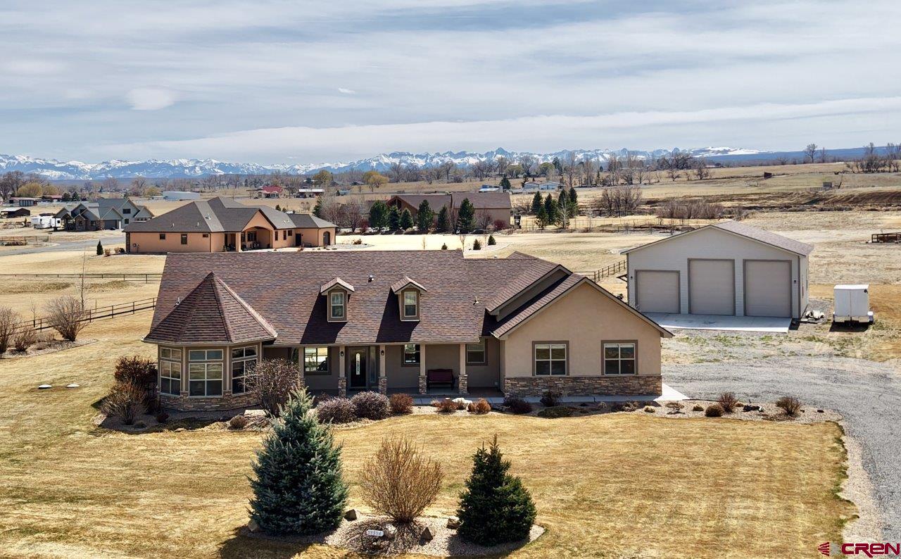 Spectacular custom home located in Dakota Vista on Spring Creek Mesa. This charming one level home features a beautiful setting with mountain views, mature landscaping with irrigation water, and a 40' x 45' insulated shop with RV doors. The shop is also heated and cooled by a heat pump and has power for welder and compressor. The interior of the home features a split floor plan, Alder cabinets & granite countertops throughout, hardwood floors in the kitchen/living/dining rooms, sunroom measuring 18'6" x 24'4", tray ceilings in the living room and Master suite, fireplace, extra wide interior doors, no steps at entry points into home and a beautiful kitchen with island. Master suite offers walk-in shower, jetted tub, double vanity sinks, and walk-in closet. Additional features include stucco and stone exterior, 3 car garage, large front and back covered patios, and a natural gas connection on back patio.