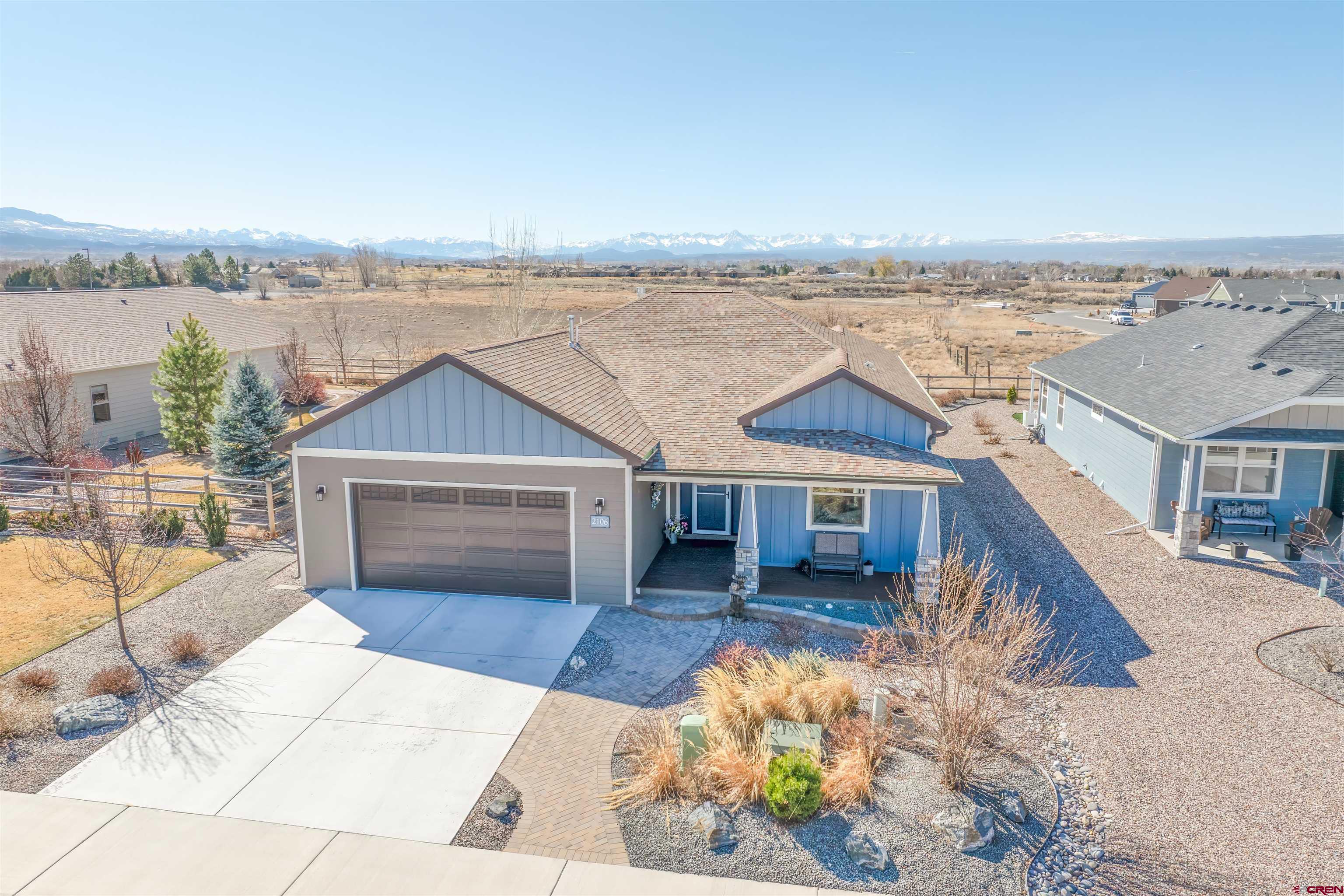 This beautiful 4-bedroom, 2-bathroom home offers breathtaking San Juan Mountain views in the heart of Montrose, Colorado. Located in a quiet community, it provides a perfect blend of tranquility and convenience. The open floor plan features a spacious living area with a gas fireplace, a mounted TV, and a theater-like experience for movies and sports.  The upgraded kitchen includes custom soft-close cabinets, pullout shelving, granite countertops, stainless steel appliances, a gas range, and motion-activated under-cabinet lighting. Nine-foot ceilings and Lifeproof* vinyl flooring enhance the home’s modern appeal, while the primary suite has an upgraded ceramic tile shower floor. Smart home features include switches, electronic door locks, motion-sensitive security cameras, and a timer-controlled hot water recirculating pump.  Designed for effortless entertaining, the expansive backyard features a new remote-controlled aluminum pergola, a large paver patio, a tranquil water feature, a natural gas fire pit, a built-in natural gas BBQ grill, and a Traeger smoker. The fully xeriscaped yard requires minimal maintenance, with complete irrigation coverage and a WiFi-enabled controller.  The garage is built for convenience, offering heavy-duty steel cabinets, a work surface, and a dedicated 40-amp, 220V EV charging outlet (installed for Tesla). With its stunning outdoor spaces, stylish interior upgrades, and lock-and-leave capability, this home offers a rare opportunity in Montrose.    Don’t miss out — schedule your showing today!