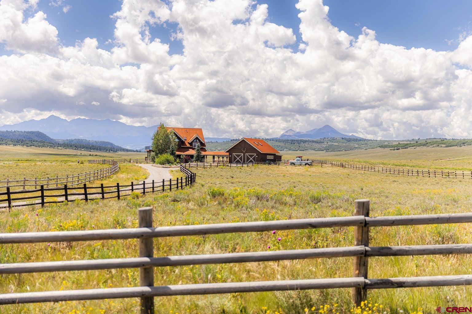 Nestled on 147 rolling acres in the heart of a sun-washed valley amid the southern San Juan mountains, this idyllic ranch is a wonderfully Western rustic retreat.At the heart of this verdant fenced pasture,sits a charming log & stone ranch house,ringed by covered porches & open decks which dramatically frame 14,000-foot peaks of the Wilson mountain range.The home's vaulted log design has been tastefully updated over the last three years & offers warm,intimate bedrooms & living spaces perfectly suited for friends & family to gather.Ideally suited for a horse enthusiast, the fenced pastures,loafing shed, tack room,equipment barn & 4-car garage are an ideal staging area for riding adventures on & off the property.