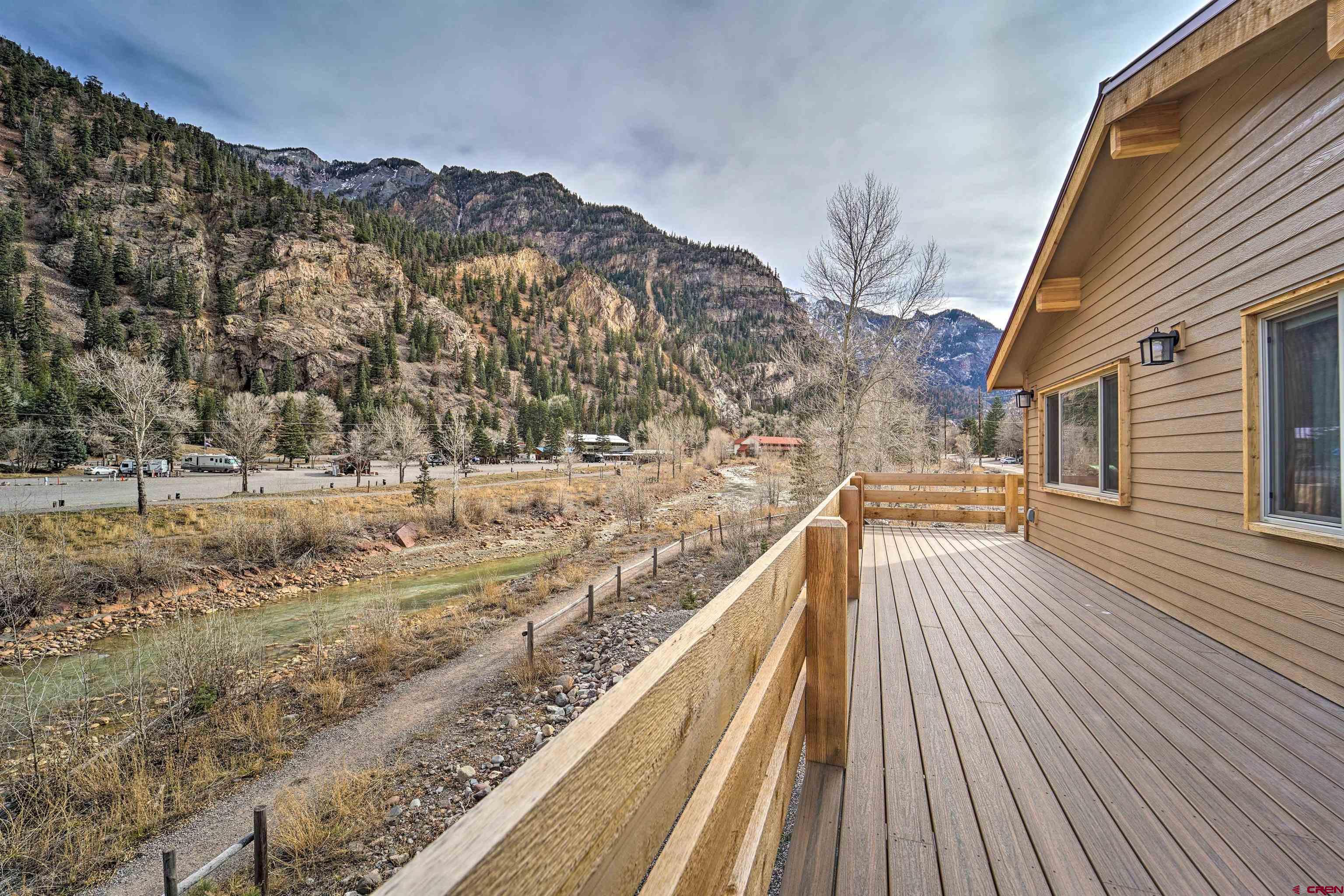 This wonderful property has 3 bedrooms and 3 3/4 bathrooms highlighted by a sunny deck overlooking the Uncompajgre river and trail. Views up and down the river and straight up the spectacular mountain sides. The home is appointed in a modern style. Two bedrooms are downstairs, each with en suite baths and patios. Completing the large large entry you will find laundry and the garage downstairs as well. The primary is upstairs off the kitchen. Plenty of parking. This has been a successful vacation rental but would also make a comfortable private residence.  Come sit by the river and savory life in the mountains.