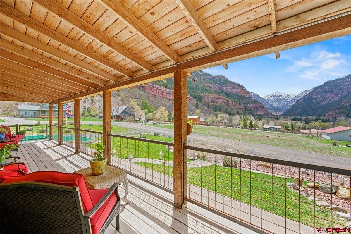 Views! Views! Views! Surrounded by the breathtaking high mountain peaks of the San Juans, this amazing log home—located in Panoramic Heights just two miles north of the city of Ouray—offers abundant windows, two sunrooms, front and back decks, and a backyard gazebo.  Throughout the property, you’ll find unique and beautiful stained glass and hand-carved artwork. Recent remodeling includes a fully updated kitchen with new appliances, a laundry closet with a new washer and dryer, and refreshed bathrooms with new fixtures. A new natural gas furnace provides efficient warmth throughout the home, while a gas stove adds additional heat and cozy ambiance to the central living area.  New in 2024: a metal roof on the house!  Eighteen solar panels atop the garage help keep electricity costs low. Attached to the two-car garage is a one-bedroom apartment, complete with washer/dryer, ¾ bath, stove top, and refrigerator.  The property is beautifully landscaped with an automated watering system, and the backyard is fenced—perfect for your four-legged furry friends.  Make your dream of mountain living a reality—schedule your appointment today!