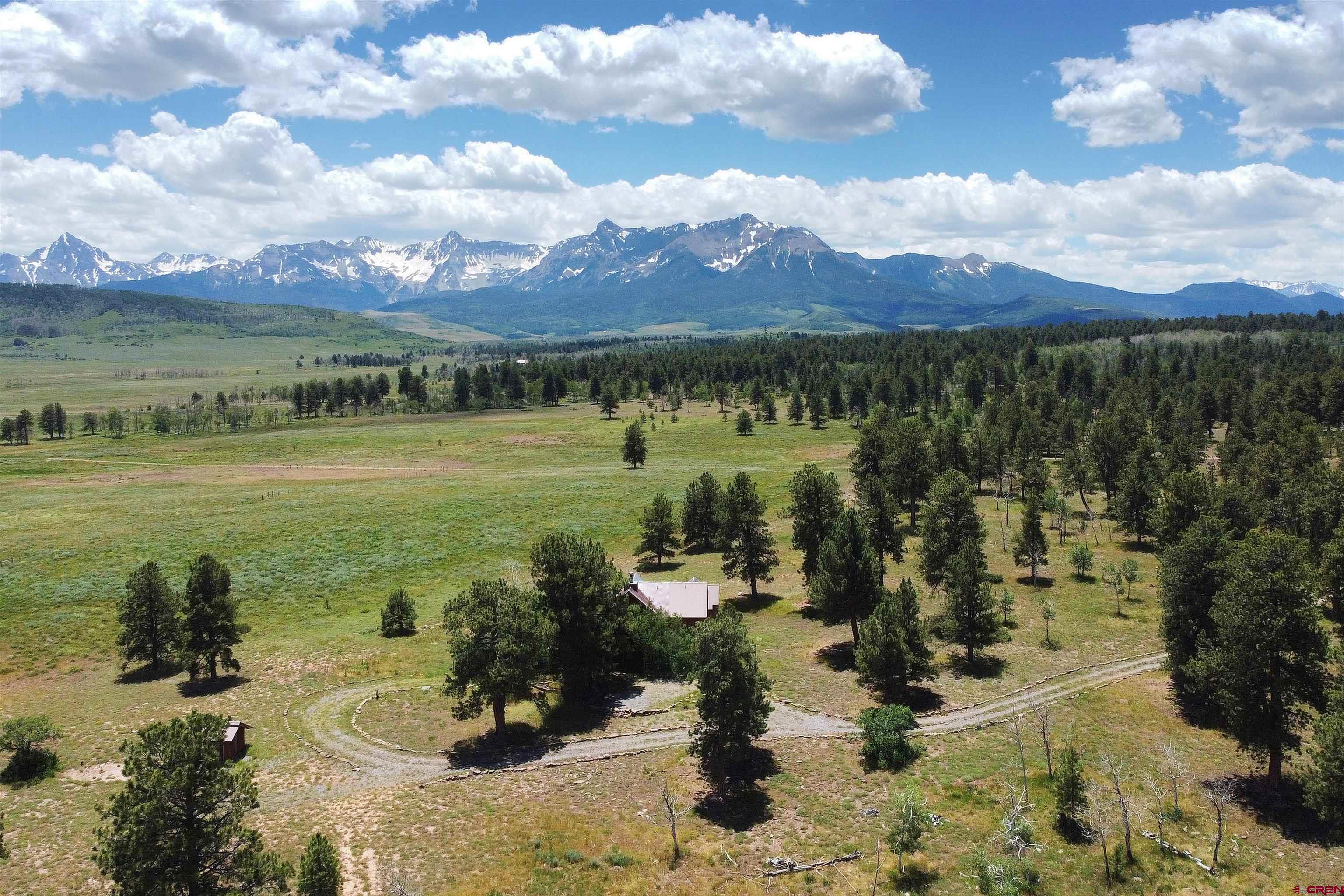 Secluded Mountain Paradise Near Ridgway, Ouray & Telluride – Off-Grid Dream Home on 40 Acres with Panoramic Views Are you searching for the perfect Colorado mountain retreat—far from city noise, traffic, and summer heat, yet still accessible year-round? This stunning 40-acre off-grid property is your gateway to Southwest Colorado’s most iconic outdoor destinations—Ridgway, Ouray, Telluride, and Montrose—and it's packed with features outdoor enthusiasts will love. Tucked into a private forested setting just off County Road 62X, this handcrafted mountain home was designed by a top local architect and built with care by some of the region’s finest builders and artisans. The result is a warm, rustic-modern escape—ideal as a year-round residence or a seasonal getaway you can easily lock and leave. From the moment you arrive, you’ll be captivated by breathtaking views of the Sneffels Range and the Cimarron Mountains. The Home This thoughtfully designed home features classic mountain finishes—natural wood, stone, cathedral ceilings, and a stunning stone fireplace. The main level includes a spacious great room, kitchen, dining area, and a cozy primary suite with a private bath. Upstairs are two additional bedrooms, a guest bath, and smartly integrated storage. Expansive decks wrap around three sides of the home, inviting you to relax and soak in the 360-degree mountain views with family and friends. Off-Grid Living with Modern Comforts -Solar-powered with a backup system -Engineered septic and quality well water -Conventional furnace for warmth in cooler months -Cell service and high-speed internet access available -No HOA, no covenants—just freedom to live your way Outdoor Lifestyle & Wildlife Haven This is prime elk and deer country, with open pastures, year-round spring-fed ponds, and cross-fenced acreage ideal for horses or livestock. Grazing leases are in place, providing agricultural tax benefits and keeping ownership affordable. With easy access to nearby county roads, you can snowmobile, ATV, cross-country ski, or ride horseback right from your door. Millions of acres of public lands and trails lie just minutes away. Expandable Legacy Property This 40-acre offering is part of a larger 240-acre estate, with five additional parcels available—including 160 acres of some of the most beautiful Colorado land you’ll find, listed separately. Whether you're looking to expand your holdings, create a family compound, or invest in your future, the possibilities are endless. Unbeatable Location -25 minutes to Ridgway -35 minutes to Telluride via Placerville and Sawpit -Quick access to Montrose Regional Airport and essential services -Surrounded by world-class skiing, hiking, biking, fishing, and off-roading This property has been cherished by one family for years—a peaceful mountain sanctuary where memories were made and dreams were lived. Now, it's ready for your next chapter. Bring your vision, your toys, your animals, and your sense of adventure—this is the Colorado lifestyle you've been waiting for.
