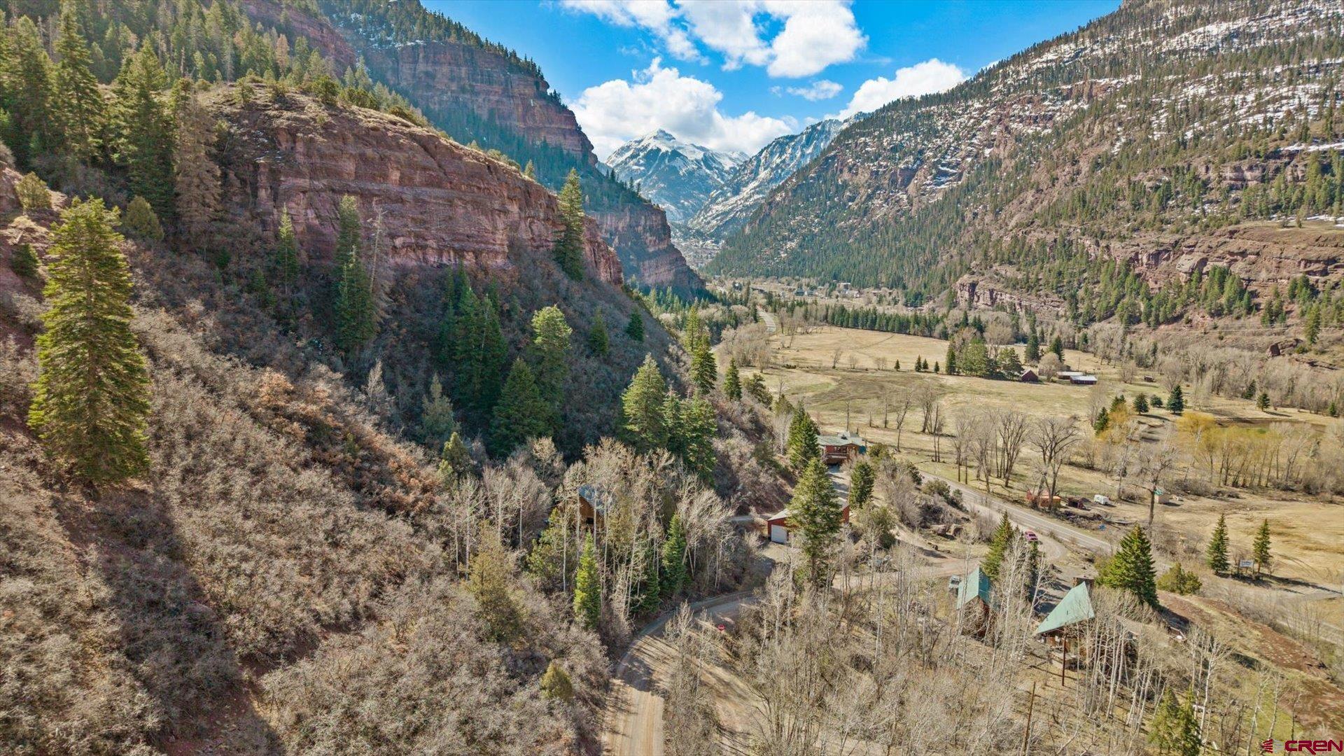 Unbelievable Opportunity and Potential in Ouray, Colorado, with Quintessential Mountain Home, Massive Shop, and Soaring Views! The perfect basecamp for everything that the best mountain range in the US has to offer, this exceptional property delivers unmatched versatility and functionality.  Let's flip the script and start with the nearly brand-new 60’ x 30’ shop of your dreams. Heated by natural gas, insulated, water tapped, equipped with endless storage, finding a property offering this amenity with easy access to Highway 550 is a needle in a haystack. Even better, no HOA or covenants allow you to let freedom reign in one of the most beautiful and special places in the world with endless recreational opportunities. Store your ATV’s and Side by Sides, your Class A RV, your project cars or whatever your hobbies are, this shop can accommodate everything you’re bringing and more. Wander up to your idyllic, alpine home in the mountains, surrounded by jaw-dropping views and majestic pine trees. Step inside to an intimate, warm environment featuring large gallery windows capturing the views and an abundance of natural light. The main kitchen/living/dining area is an open layout, with a fireplace, vaulted ceilings, and provides a wonderful haven for rest and relaxation after unforgettable adventures in the San Juans. The home has 3 bedrooms to accommodate everyone, and even has a mutli-use laundry/utility room to keep the mess out of sight. Sip your favorite beverage and soak in spectacular scenery on your front porch, or wander over to your own private firepit with Whitehouse Mountain towering above you. Restorative and just plain fun hot springs, more jeep trails and passes than you can imagine, world class skiing in Telluride, hiking, mountain biking and trail running singletrack in every direction, everything from elevated cuisine to greasy bacon cheeseburgers to handcrafted, local breweries, curated and creative shopping on every corner with unique, alpine experiences everywhere you look. Capitalize on the versatile valley zoning in this unmatched location, allowing you to solidify your assets in what would be an excellent, cash-cow investment property. You’ll have to pinch yourself walking down main street. You’re not dreaming. This is the magic of Ouray, Colorado. Come Discover It and Make this Incredible Property Your Mountain Basecamp Today!