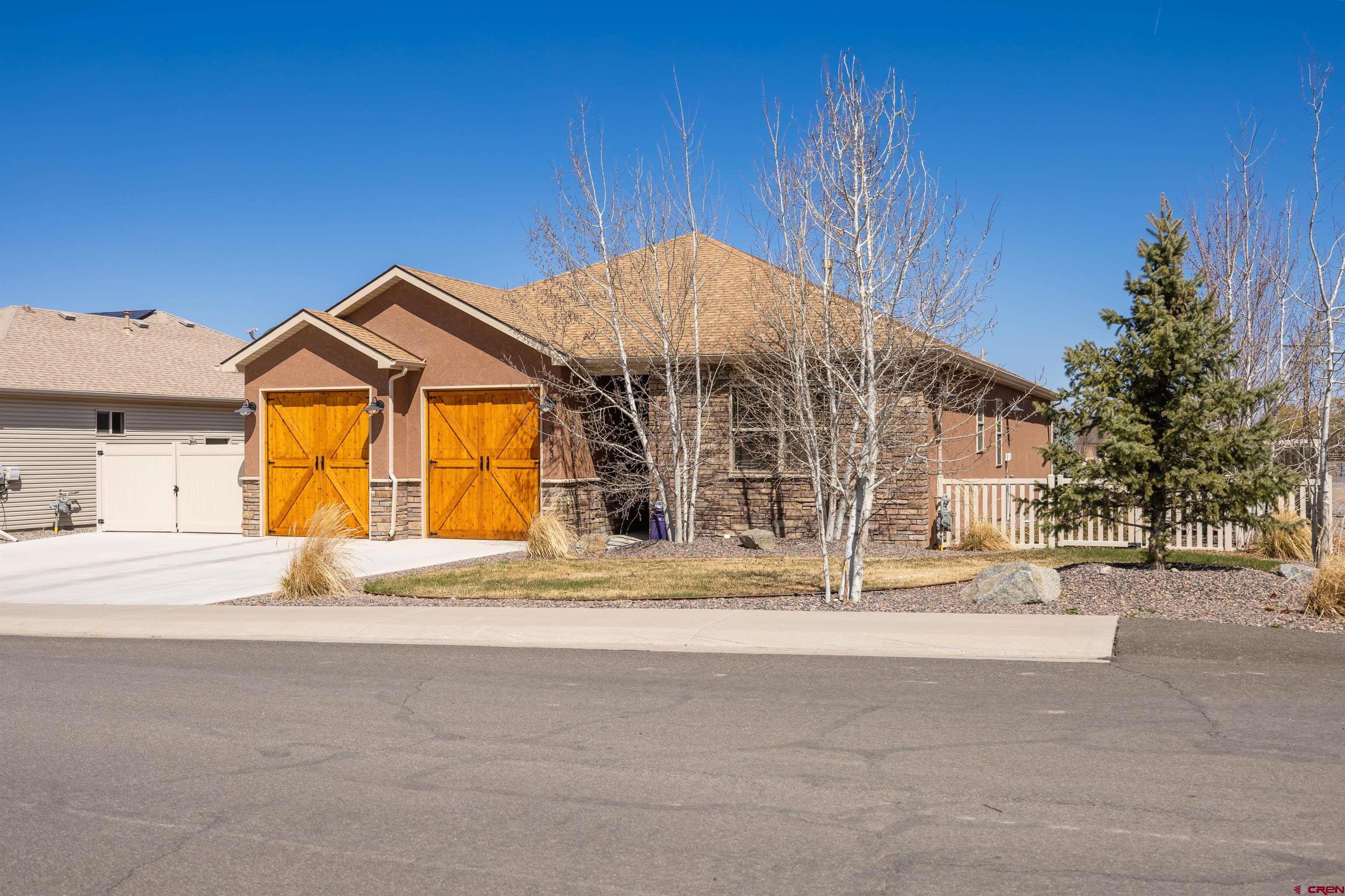 This beautiful single story home in Montrose's coveted Preserve subdivision has been meticulously maintained and is move-in ready! Built in 2020 by Outwest Homes, this home features stunning knotty alder touches, vaulted ceilings, attractive laminate flooring, a floor to ceiling rock-surround fireplace and knotty alder mantel. The kitchen, featuring granite countertops, stainless steel appliance package, and a spacious pantry, opens into the bar seating and separate dining area. The two spare bedrooms are very amply sized, and separated by a full hallway bathroom. One of the spare bedrooms includes a built-in safe tucked into the large double closet. The master suite is quite spacious, features lovely windows as well as access to the back patio, and a large wide dual sink vanity master bathroom with walk-in shower with dual shower heads, and well appointed walk-in closet. Outside, just off the covered patio, is the fully professionally landscaped back yard space, as well as a custom shed complete with electricity to it, and the path behind the home which is nestled against the protected wetlands nature preserve which neighbors this property. Fully fenced back and sides, there is also a concrete RV parking pad on the side of the home. Other perks of this home are the drop down storage hatch for attic storage in the garage, a whole home Culligan soft water system, osmosis drinking water system in the kitchen, and a whole-house humidifier.