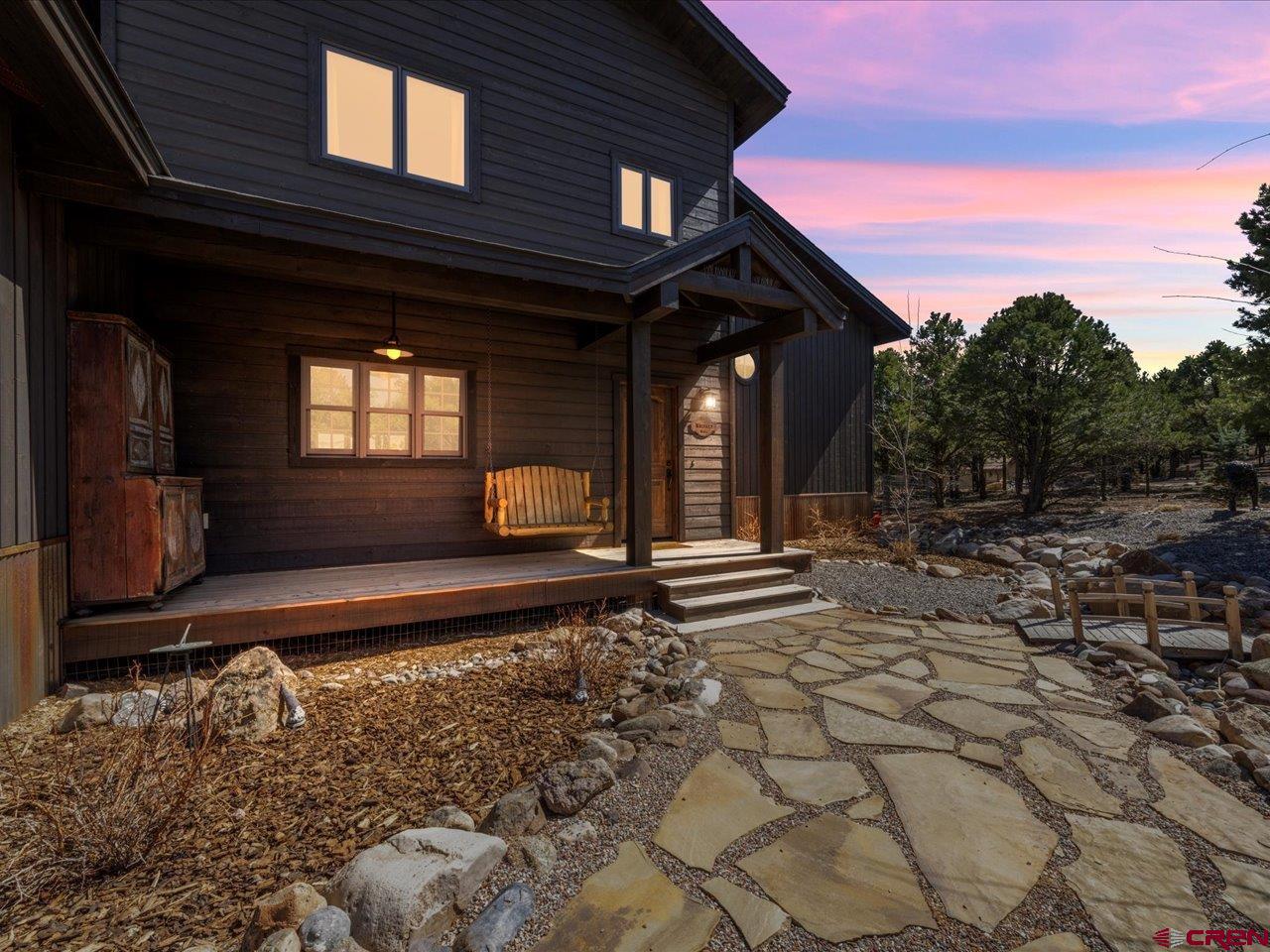 Welcome to this idyllic home referred to as Whiskey Ridge. Perfectly situated on a Log Hill village escarpment lot this 2-acre property overlooks the iconic San Juan and Cimarron mountains ranges and the Ridgway Valley Floor. This gorgeous (like new) mountain modern home was built in 2021 by the renowned local construction company Blackthorn Builders. The open concept living/dining room offers rich oak flooring, spectacular views, cathedral ceilings with expansive windows allowing tons of natural light.  The grand floor to ceiling stone chimney houses an oversized wood burning fireplace for those wintry nights.  Custom reclaimed barnwood cabinets enhance the beauty of this one-of-a-kind kitchen, starting with a Viking 5 series 6 burner gas oven range with stainless steel vent above.  Wall mounted, farmhouse brass pot filler over the range.  Soapstone counters tops are accented with leather like granite island top. Stainless appliances include a Kitchen Aid side by side fridge, Sharp Carousel microwave, GE Profile dishwasher and under cabinet wine cooler. The list goes on. The main floor also includes 2 guest bedrooms, generous closets offering lots of storage, half-bath with a stone sink, and a guest bath with custom-tiled walk-in shower. Every room has a view!  The stunning oak and metal staircase leads you to the second level that has a reading nook with built-in shelving and storage. Next is the billiard /office room suitable for 7’ billiard table or home office. Then there is the spacious primary bedroom with a private deck and panoramic mountain & valley views. A large walk-in closet has built-in shelving and Whirlpool washer and dryer. The large tiled walk-in shower offers a spectacular view of the mountains and valley.  The soaking tub has a marble surround and a marble vanity. The bathroom features waterproof faux oak flooring.   Other features of the home include Central Air, Forced Air Heating, Central Humidification system. 6 person hot tub on the back deck. High speed internet and dimmable, recessed lighting throughout, with attached 2 car garage. Ridgway is conveniently located between the historic mining town of Ouray and the world-class ski resort in Telluride.  Montrose is the local supply town north just 30 minutes away with a regional airport, excellent health care facilities and shopping. The famous Divide Ranch and Golf Club is just minutes away.  Make your appointment today, this is truly a great place to call home.