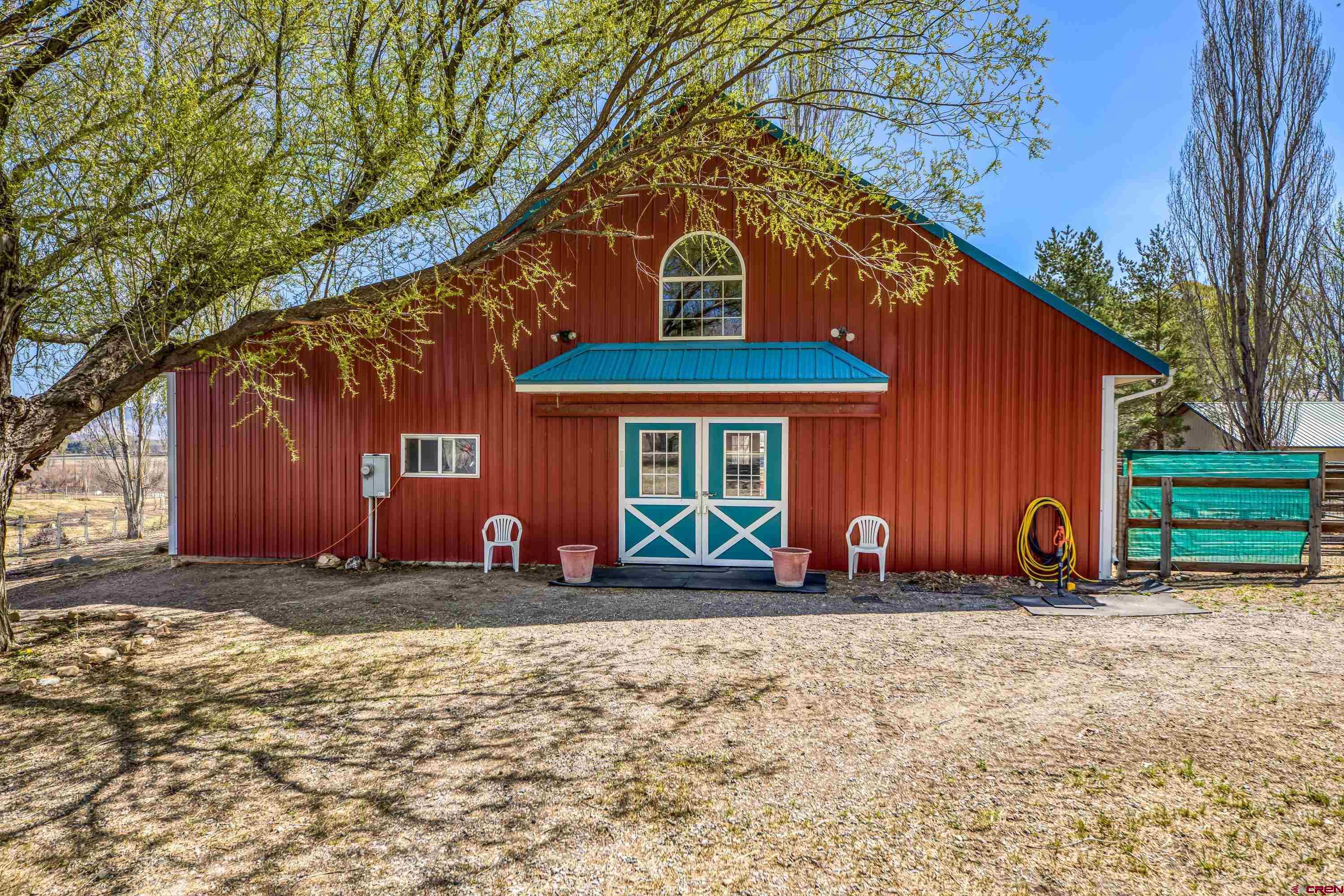 Imagine a horse property nestled on 5 irrigated acres of land, surrounded by lush greenery, garden spaces, scenic landscapes and even distant mountains on the horizon. Privacy here reigns supreme, with natural barriers like tall trees forming a cocoon of serenity around the estate.  The location is prime—accessible yet tucked away. It’s close enough to conveniences like local shops, schools, and equestrian trails, but far enough to feel secluded. The property features pastures for grazing, sturdy fences, and even a charming 48x36 barn with spacious stalls, a tack room, wash bay, hay storage and kitchen/break room. There is a finished bonus room above the barn for overnight quests or a helper's bunk. There is a regulation sized riding arena for training and practicing.  At the heart of the property, there’s a charming 2 story home with 2 car attached garage classic architectural details, open concept, vaulted ceiling and a loft overlooking the family room with a lovely fireplace. Large mudroom to kick off your boots and a greenhouse/sunroom for all your herbs and flowers. A walkout 1 bedroom, 1 bathroom apartment below with a kitchen, dining area and living room. Adjacent to the main home is a tiny house with a modern twist, perfect for guests, a private retreat, or a creative workspace.  This haven is designed to offer peace for both horse and human, where every sunrise over the fields feels like a gift. Does this vision match what you had in mind?