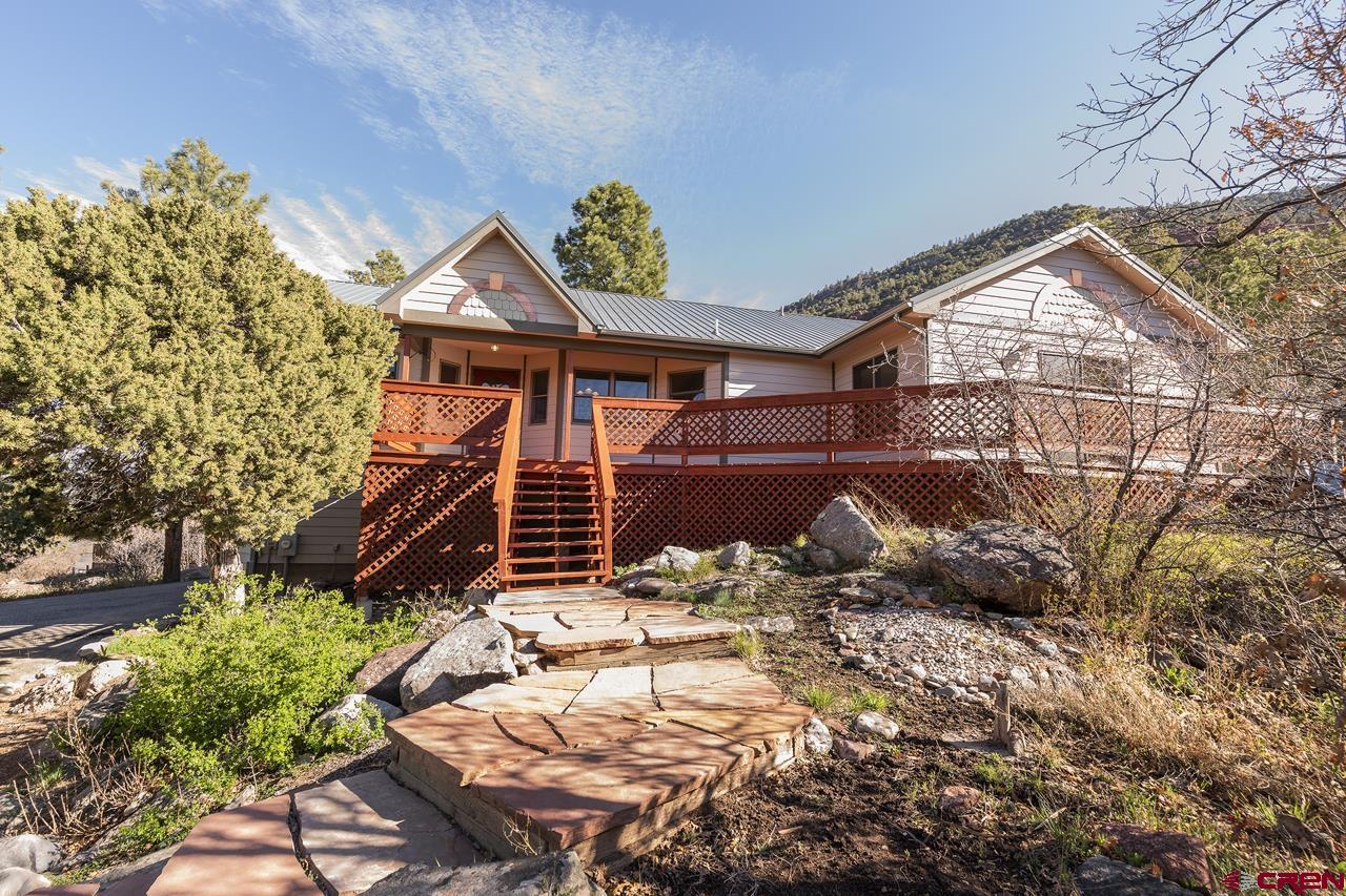 Welcome to Ouray County and an ideal property to make your home in SW Colorado.  Located just off Hwy. 550 in the Ponderosa Village subdivision and roughly midway between (and short distances from) the mountain communities of Ridgway and Ouray, this home enjoys end-of-road privacy with a circular driveway and stunning mountain views.  The spacious main floor includes separate dining and living room areas, as well as a large family room that opens onto the south-facing deck.  And the pellet stove in the family room makes for a warm and cozy setting during chilly weather.  The kitchen features a nice breakfast nook area, and the laundry room - just off the kitchen at the top of the stairs to the garage - has additional cabinets for laundry goods and convenient storage.  The primary bedroom, bath and walk-in closet are on one side of the living room and the hall bath, and two other bedrooms are on the opposite side.  One bedroom includes a built-in desk, and the other bedroom includes a walk-in closet.  All bedrooms have overhead fans and there is gas-fired, hot-water baseboard heat throughout.  With room for all your outdoor gear and other storage needs, the 1000+ ft2, oversized 2-car garage includes heated workshop space with cabinets and countertops, and a heated half-bath.  Another helpful feature is non-potable, irrigation water provided through the subdivision via a frost-proof spigot on the property.  And you’ll enjoy your time outside by relaxing on the deck and/or the adjoining patio and backyard.  Don’t miss this outstanding Ouray County home - Plan your visit soon!  (Some photos of this listing may include virtually staged amenities, furniture or fixtures.)