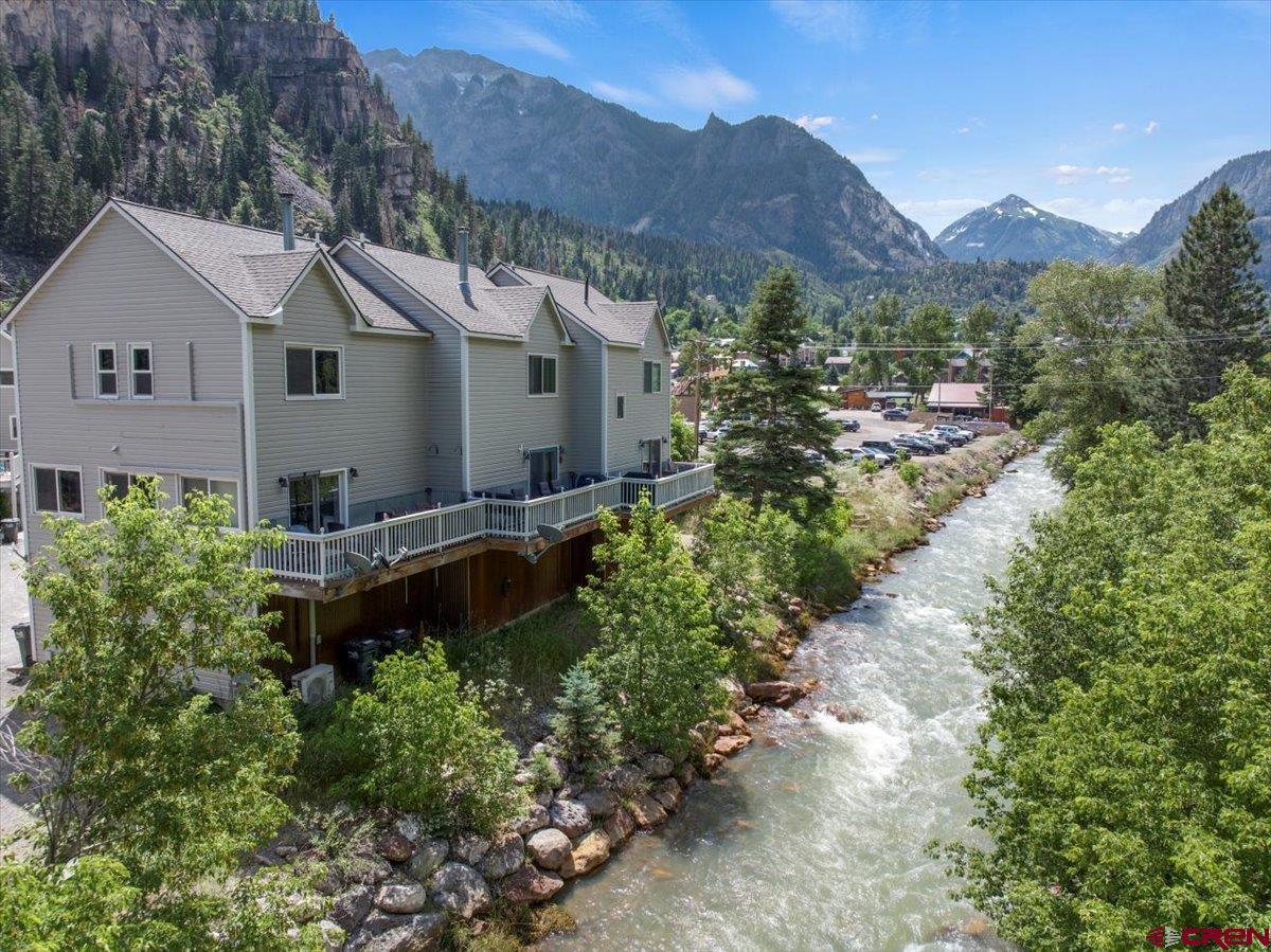 Move-in ready, FULLY FURNISHED end-unit townhome on the Uncompahgre river in Ouray! Stylish 2BR/1.5BA, 1200 sq ft. fully remodeled with recent Boreal split system HVAC, windows, floors, & appliances. Private deck with mountain & river views. Wood stove, 1 car attached garage, and fast fiber WiFi. Super desirable location - just steps to the Hot Springs, Perimeter Trail & Downtown. Bright, cozy, stylish, & private. Includes ALL furnishings. Walk to hiking, dining, & year-round outdoor fun. Currently a licensed short-term rental with a very strong history. Ideal income property or private residence. This property has bookings through September that the owners will transfer to the new owner!