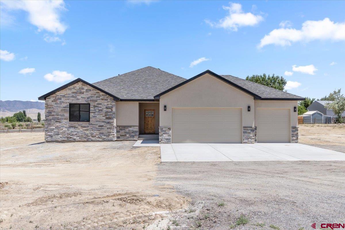 This beautifully crafted 1,958 sq. ft. home by Faucett Builders sits on a generous 1-acre corner lot with no HOA and breathtaking views—the perfect combination of privacy and freedom.  Inside, you’ll find a spacious open floor plan ideal for entertaining, with a large living room, dining area, and chef-inspired kitchen. The living room features a cozy gas fireplace with a stone surround, shiplap detail above, and a custom knotty alder pine mantel. Two TV mount locations provide flexible viewing options.  The kitchen is a showstopper, showcasing dual-toned maple cabinets with craftsman-style doors in an almond stain. Cabinet heights vary for visual interest and culminate in a full-size pantry. At the center is a 103-inch quartz island with sage colored cabinets featuring a farmhouse sink and built-in appliances—perfect for gatherings and culinary creativity.  Throughout the home, you'll enjoy pet-friendly luxury vinyl plank flooring, plush carpet in the bedrooms, and stylish tiled bathrooms. The split-bedroom layout offers a private retreat in the primary suite, complete with a walk-in closet, freestanding soaking tub, custom tiled shower with stone accents, and dual vanities.  Two additional bedrooms (approximately 12x11 ft), a second full bath, and a dedicated office or flex room with sliding barn door provide flexibility for family, guests, or work-from-home needs.  The oversized 3-car insulated garage includes extra space for a workshop and connects to a convenient laundry/utility room with a sink and built-in storage. The expansive lot provides room for RV parking, outbuildings, or toys, and is governed by light covenants—with no HOA restrictions.  Builder is in the process of providing landscaping to the front and side of the house.  This home is move-in ready and available for viewing—don’t miss your opportunity to own this one-of-a-kind property!