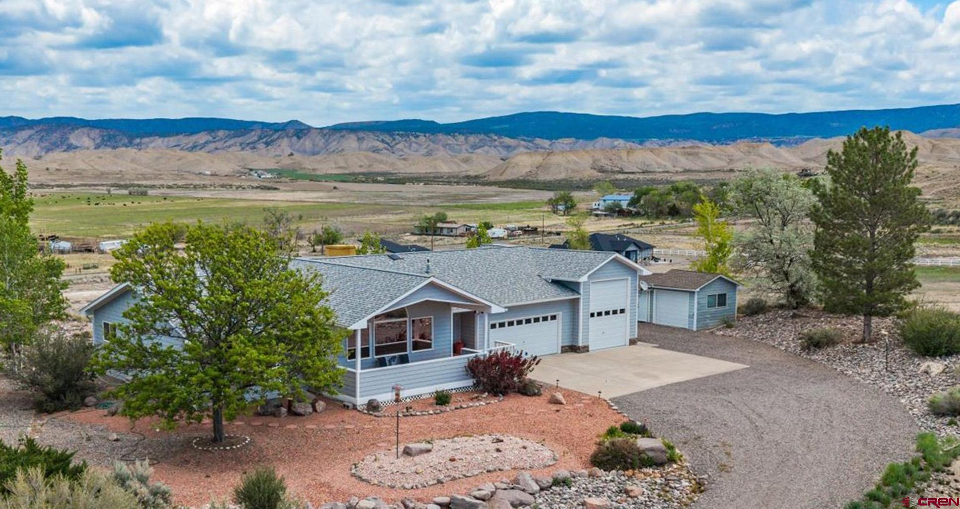 Spectacular Marriage of Unmatched Mountain Views in a Breathtaking Atmosphere, Complete with a Perfect Floor Plan and Huge RV Garage! Elevated above sprawling Western Colorado Farmland and featuring larger-than-life views of the San Juan Mountains, this exquisite estate offers exactly what you are looking for and more. Nestled on over an acre, this ideally placed home blends convenience with indulgence everywhere you look. Take a deep breath and enjoy your morning coffee, watching the sun rise over the Cimarrons, on the massive, covered front porch, and your favorite adult beverage, watching the sun set shine upon the majestic San Juans over the Uncompahgre Plateau on the picturesque and private back patio. Step inside to an excellent, split floor plan, with an open concept kitchen/living/dining room setup. You'll have to pinch yourself while you entertain your loved ones, sitting on the couch or dinner table, natural light streaming through beautiful gallery windows as you gaze upon magical views in every direction. The kitchen also provides an island, plenty of counter space, real wood cabinetry, and a large pantry. The living room features a wall of built-ins, a fireplace, and dormer windows. The en-suite has a perfectly ergonomic layout, with a spacious walk-in closet, extra room for a yoga mat or reading nook, and a large soaking tub framed by amazing scenery. Step into the garage of your dreams with an oversized 2-car bay, which is extra deep, combined with an absolutely huge 3rd RV bay with a workshop. This space will allow you your own haven for tinkering, projects, storage, and anything else you bring with you. The garage also provides a wall of shelving, making storage a breeze. Outside, you'll find an additional workshop outbuilding with power, which could be utilized to store garden equipment, an ATV, tools, and more! Colorful and expressive Colorado is all around you, with beautiful Aspen and Pine Trees surrounding the home, as well as an incredibly low-maintenance exterior with manicured xeriscaping. Located minutes from a world-class recreation center, quality healthcare, fine dining, trendy breweries, and shopping, not to mention unbelievable recreational opportunities in every direction, this property is a no-brainer. Make These Flawless Mountain Views Yours to Keep, Complete With A Home Bursting with Character and Beauty and the Garage of Your Dreams; Experience it For Yourself Today!