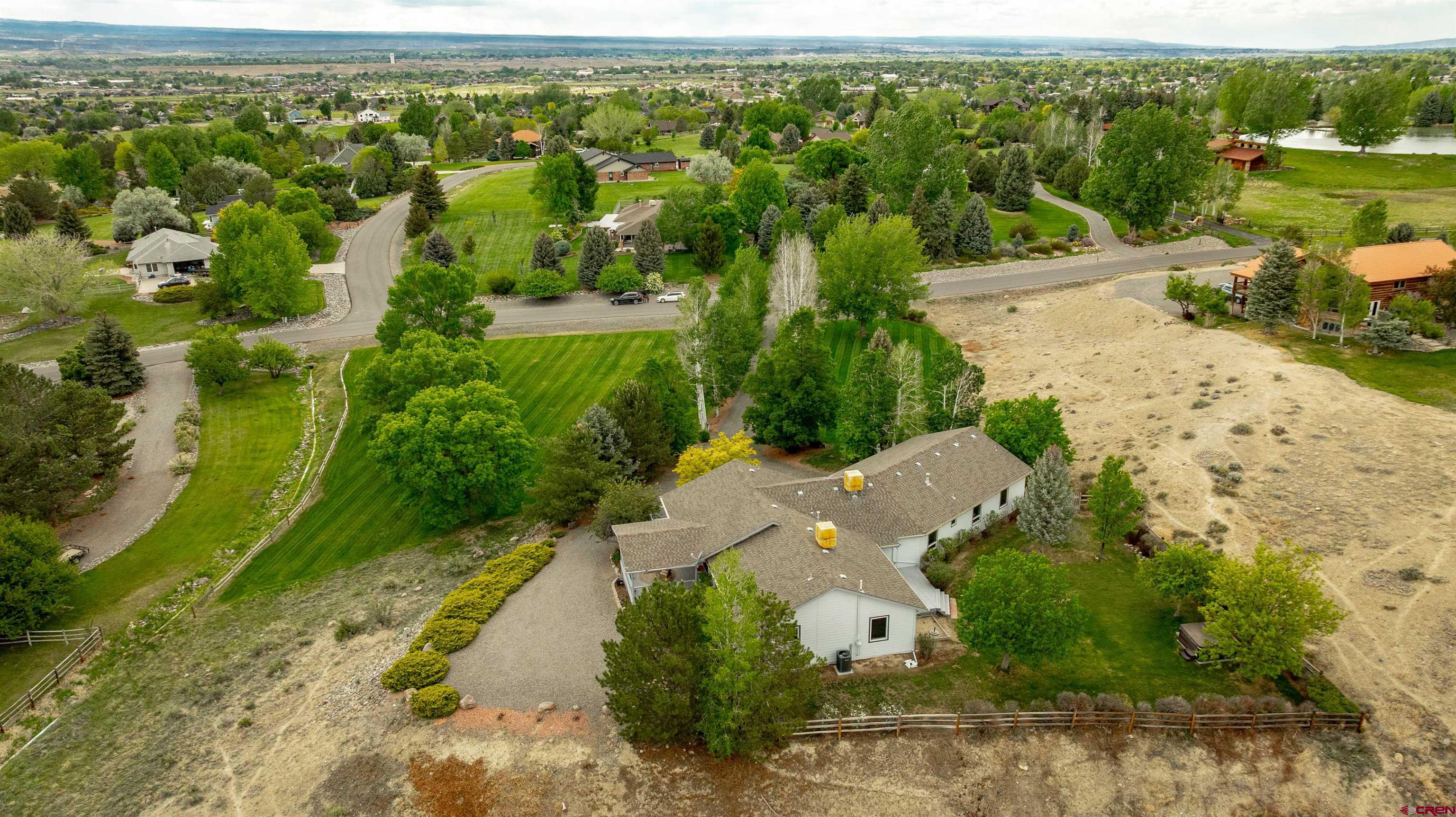Welcome home to an exceptional 3,540 sq ft home nestled on 2.34 acres in the sought-after Solar Hills Ranch Subdivision of Montrose, Colorado. Ideally positioned on high ground, this property offers both privacy and sweeping panoramic views of the surrounding mountain ranges and the valley below.  This 5-bedroom, 4-bathroom residence has been thoughtfully updated with fresh interior and exterior paint, brand new carpet throughout, new windows, and new exterior doors. Inside, you’ll find expansive living spaces including a large office, a spacious rec room, a solarium, and plenty of room to suit your needs. The huge 3-car garage offers ample space for vehicles, gear, or a workshop and the large walk-out basement offers the perfect place for a home gym, home theater or whatever you can imagine.  The southeast wing features a primary suite with an attached bath and walk-in closet, plus two additional bedrooms and a full bath. On the north side, two more bedrooms each include their own bath with a shared Jack-and-Jill shower and are situated next to a generous rec room—perfect for guests, kids, or entertaining.  Outside, you'll find yourself immersed in a park-like setting with mature trees, established landscaping, and a lush lawn kept green with irrigation water provided by the HOA. An automatic sprinkler system ensures easy, low-cost maintenance. Wildlife lovers will enjoy regular visits from deer and a variety of local bird species. Multiple decks offer serene spaces to relax, including a private area with a hot tub and a securely fenced backyard ideal for kids or pets.  Combining the tranquility of nature with the convenience of being just minutes from town, this property is a rare find in one of Montrose’s most desirable neighborhoods. Don’t miss your chance to experience comfort, space, and scenic beauty in this truly elite home.
